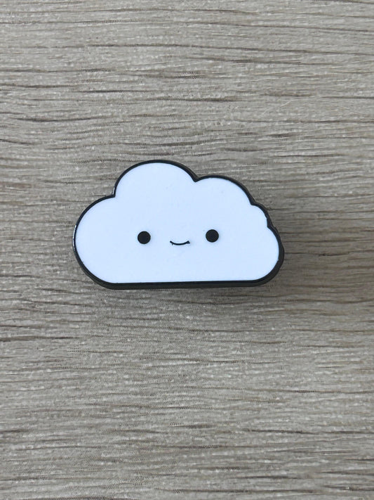 Pin's nuage souriant bleu clair à contour noir, yeux ronds et sourire discret.