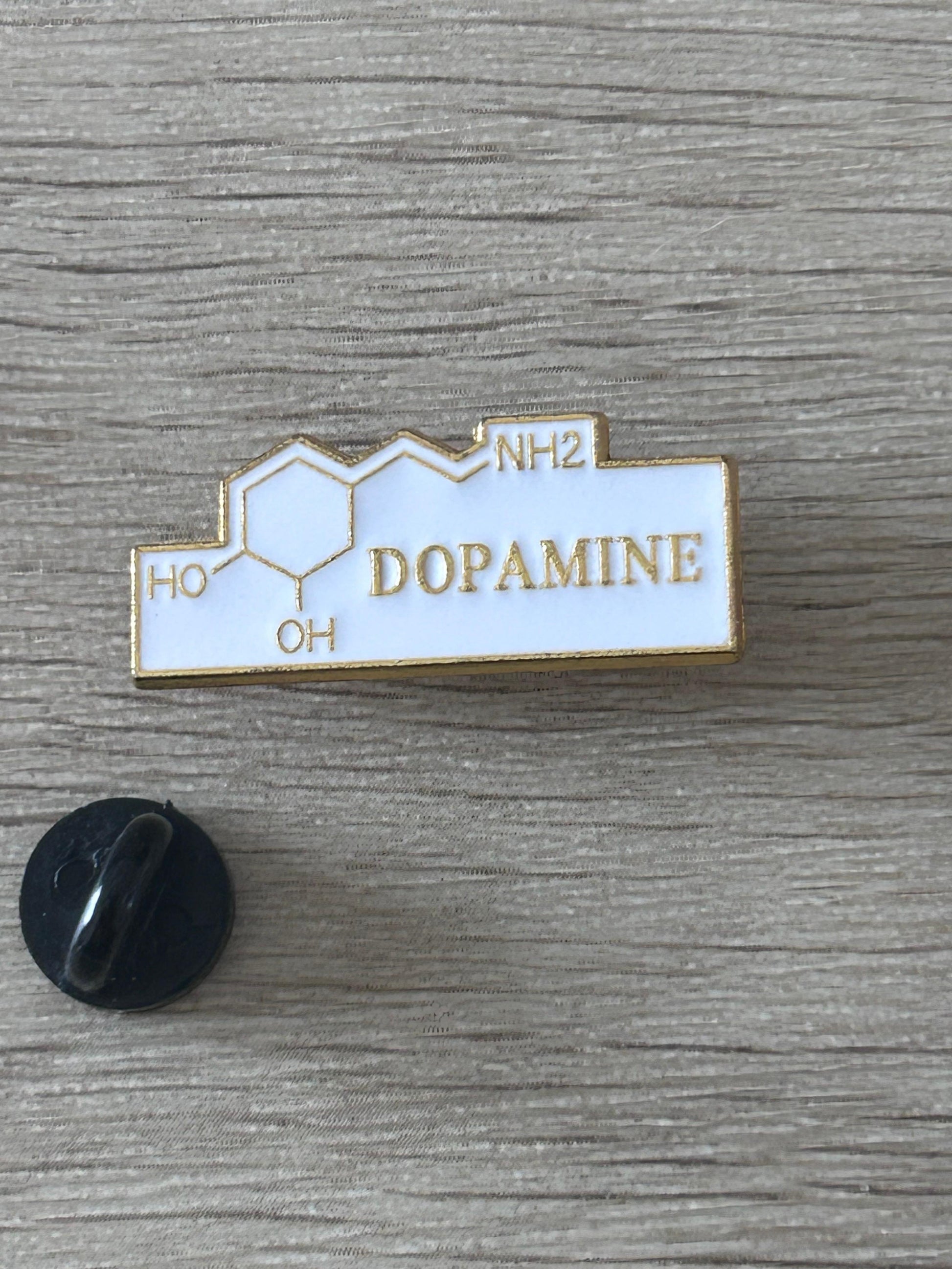 Broche rectangulaire émail blanche, contour doré, DOPAMINE, symboles HO et NH2, épingle noire.