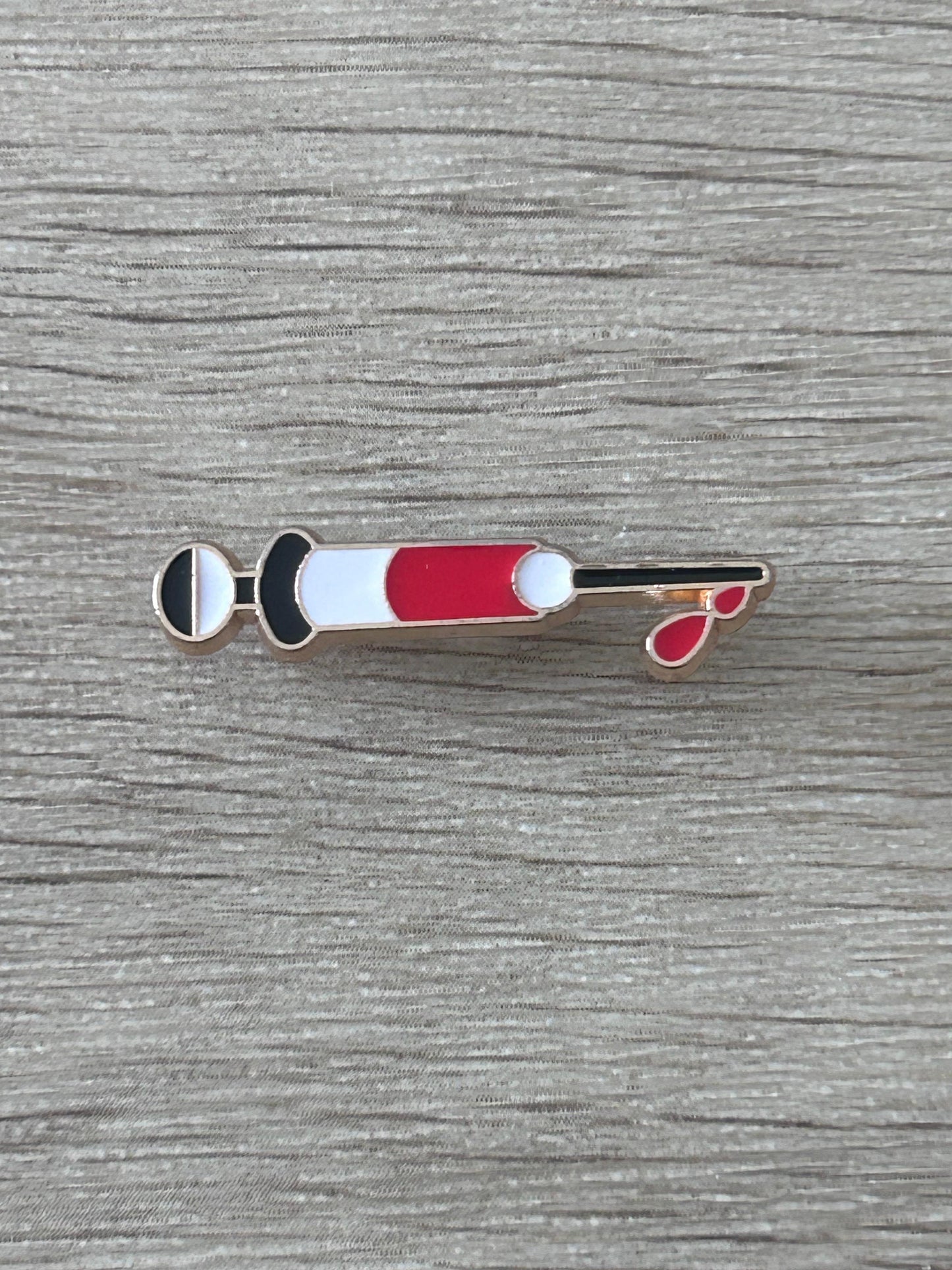 Épinglette en forme de seringue médicale rouge et blanche