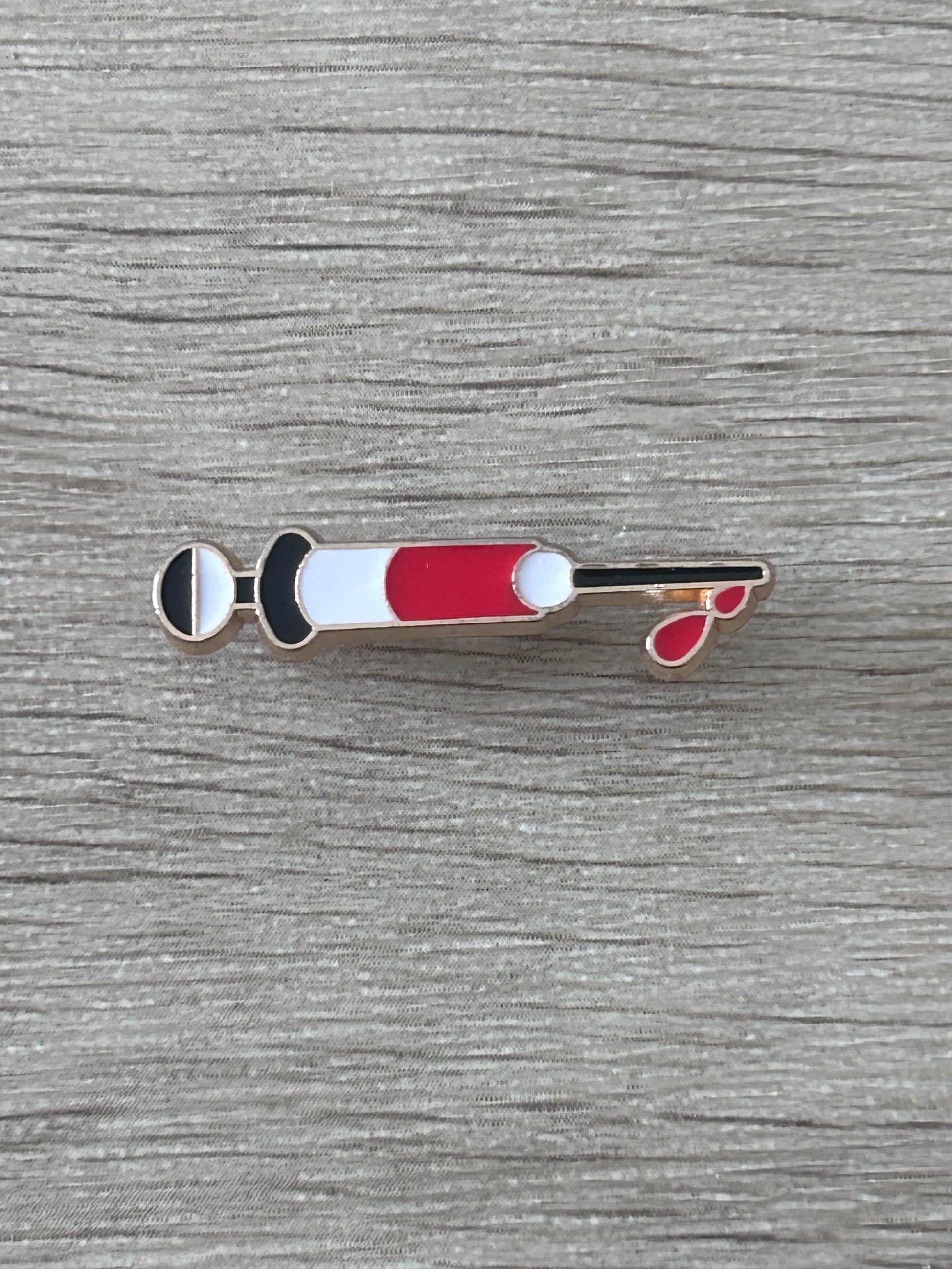 Épinglette en forme de seringue médicale rouge et blanche