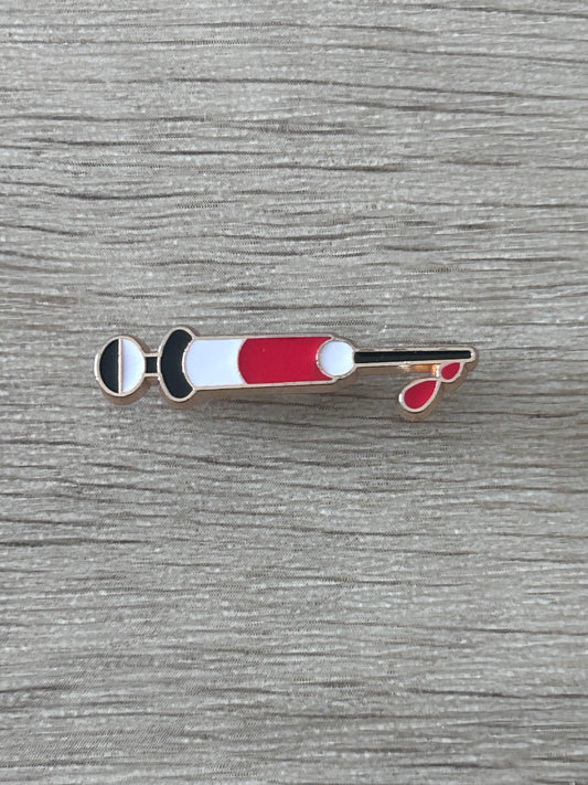 Épinglette en forme de seringue médicale rouge et blanche