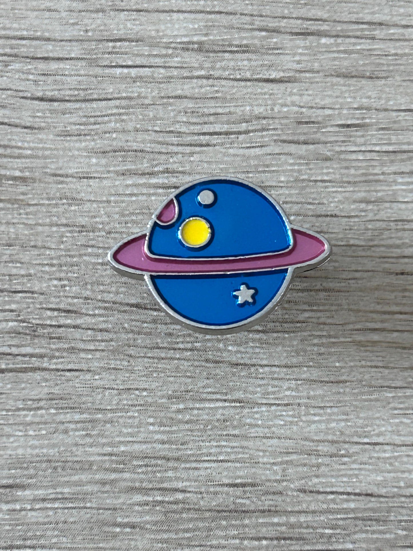 Broche émaillée planète bleue aux anneaux, étoile et soleil jaunes