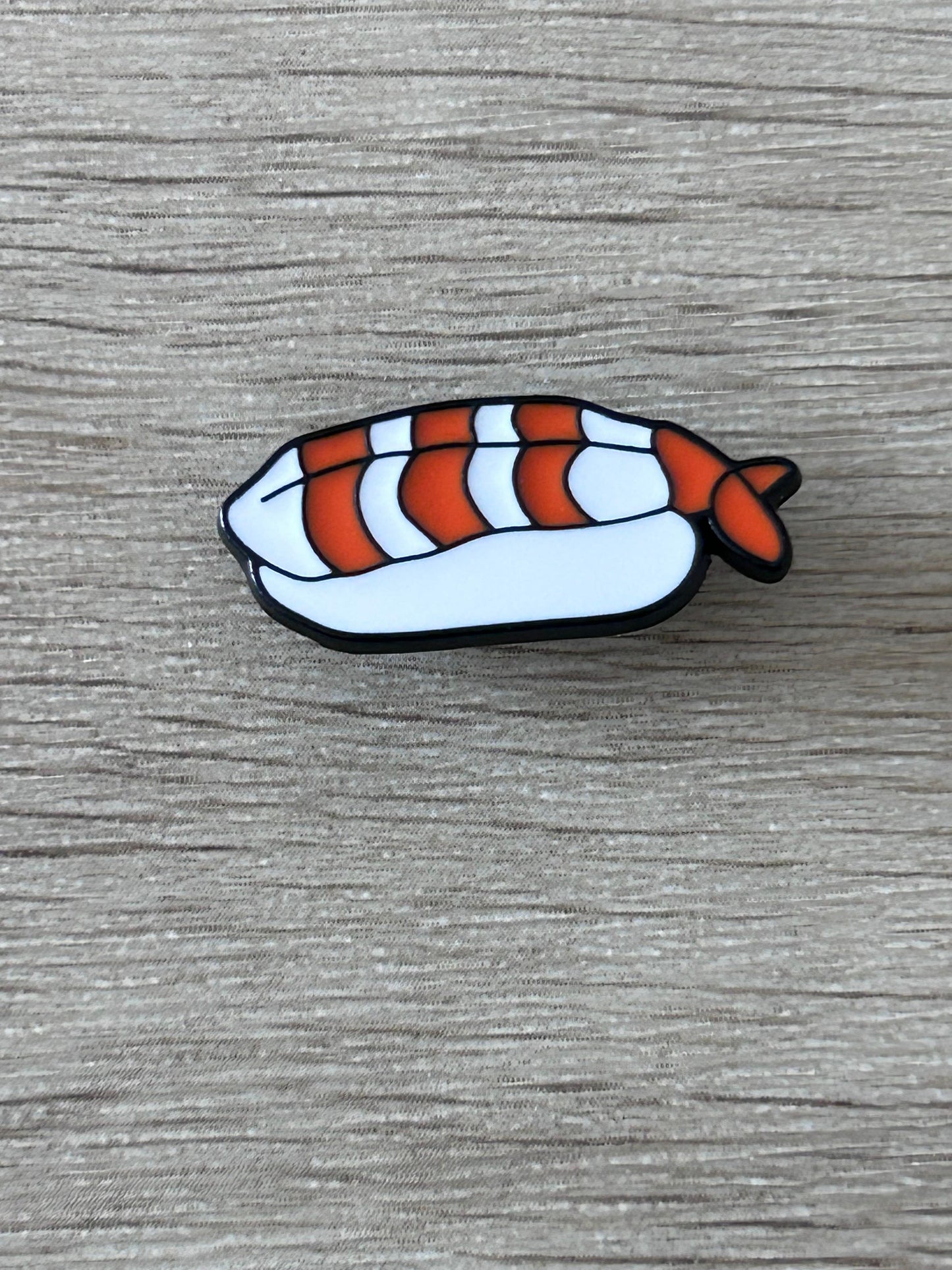 Pin's en forme de nigiri de crevette, blanc, stries bleues, queue orange