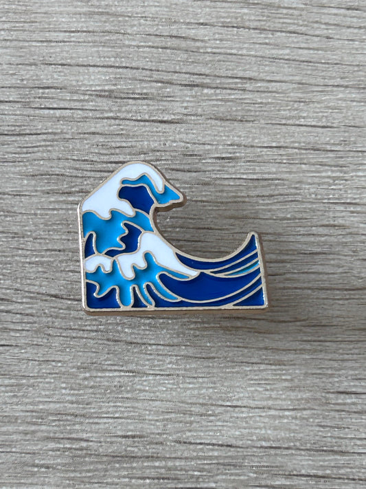Pin's émaillé vague bleu et blanche, bord argenté, motif de grande vague