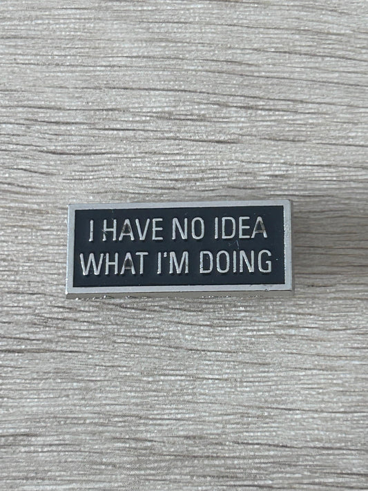 Épinglette noire rectangulaire avec texte « I HAVE NO IDEA WHAT I'M DOING »