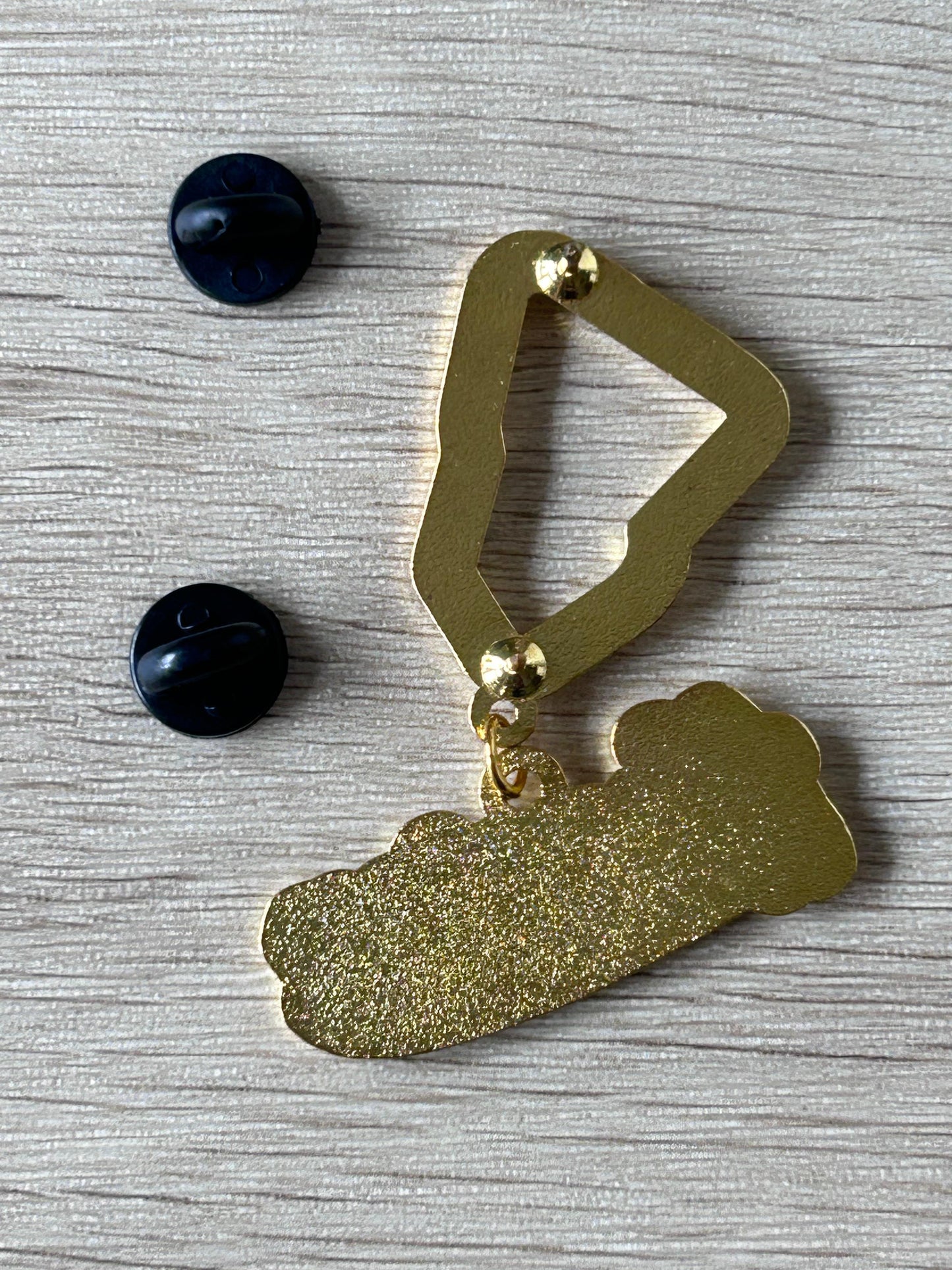 Broche pendentif doré Houston, forme bouclier, strass visibles et attache à l’arrière