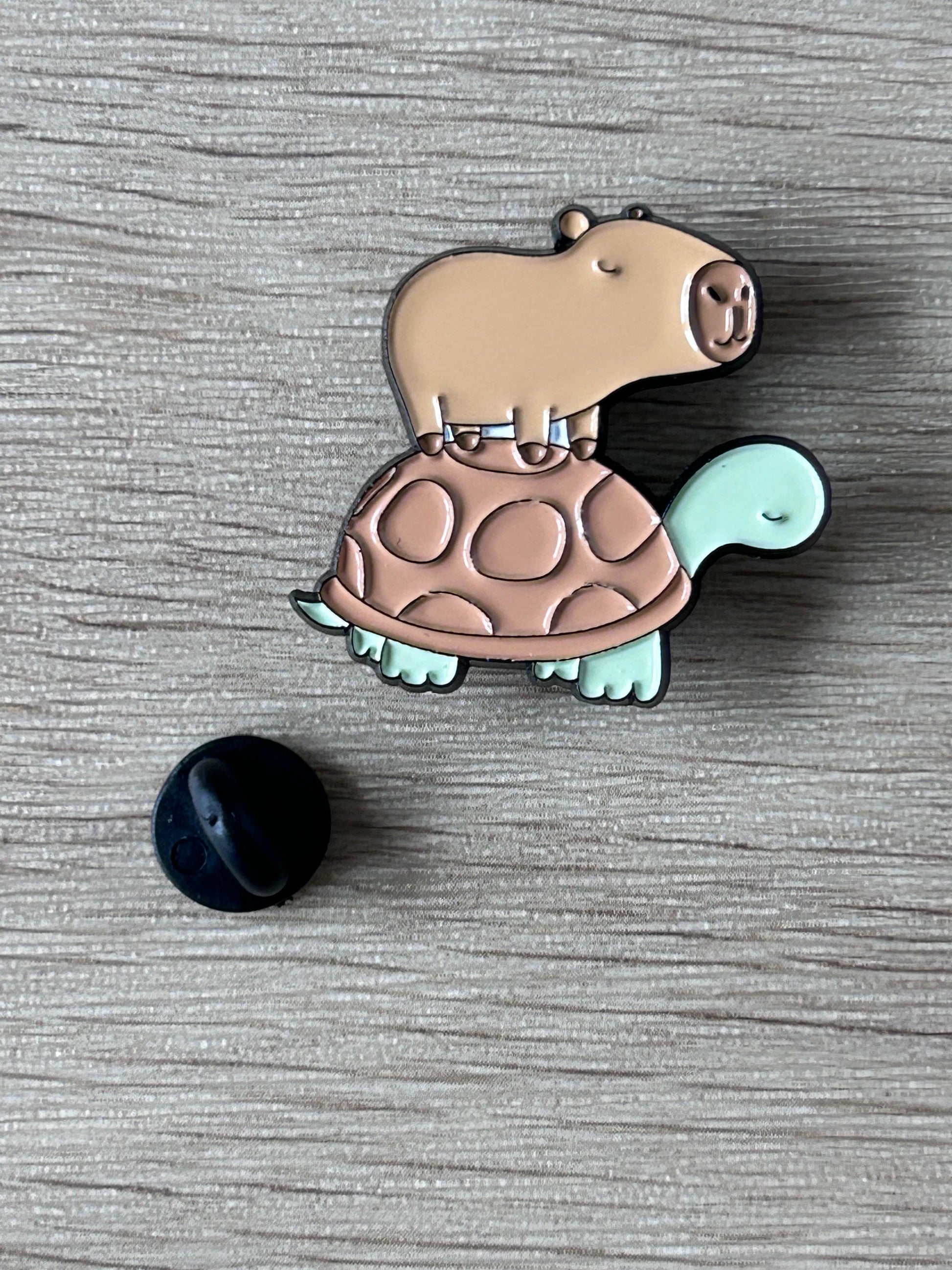 Broche émaillée capybara sur tortue, beige, coque menthe, fermoir noir visible