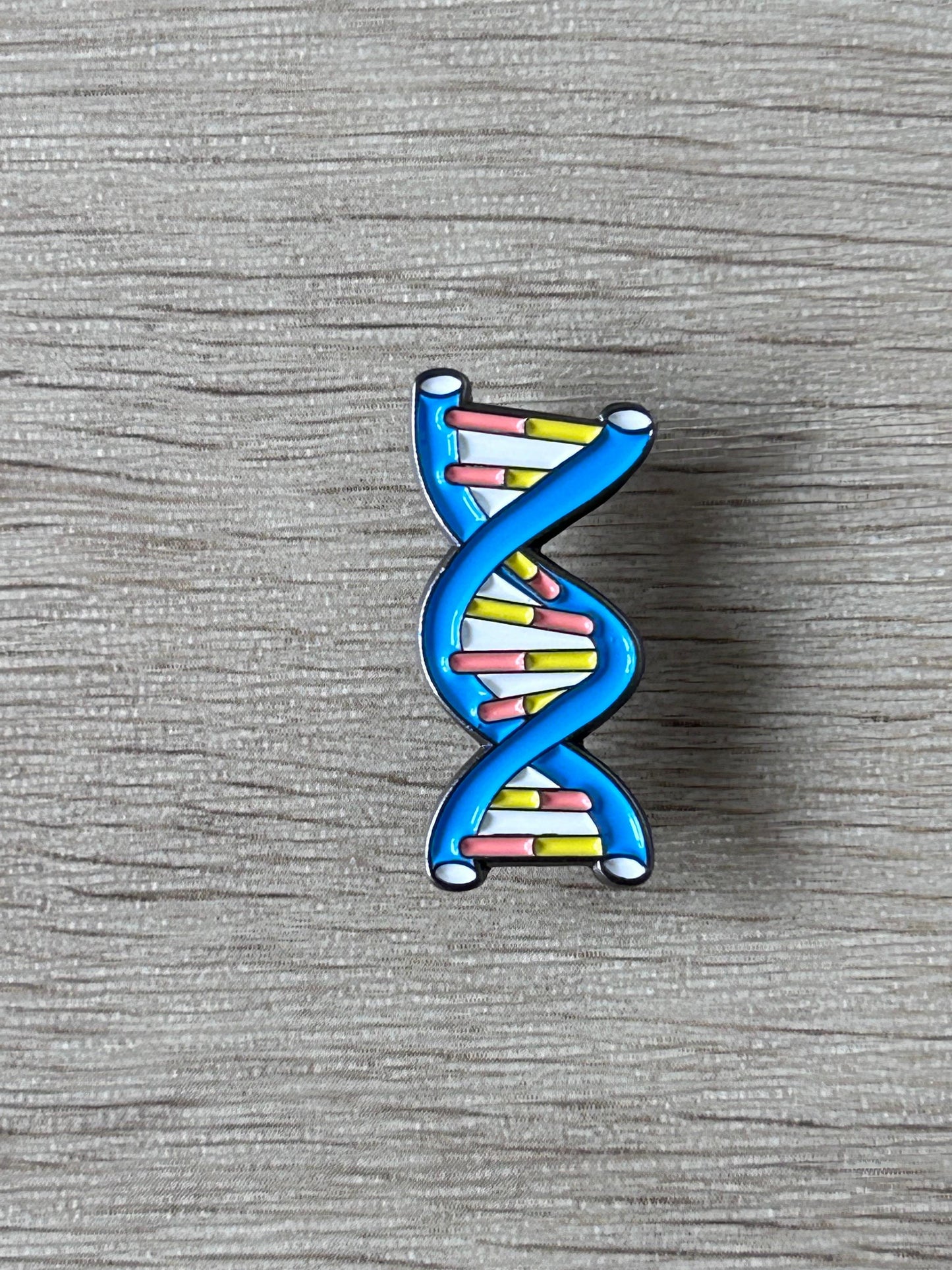 Pin's double hélice ADN bleu avec barrettes multicolores