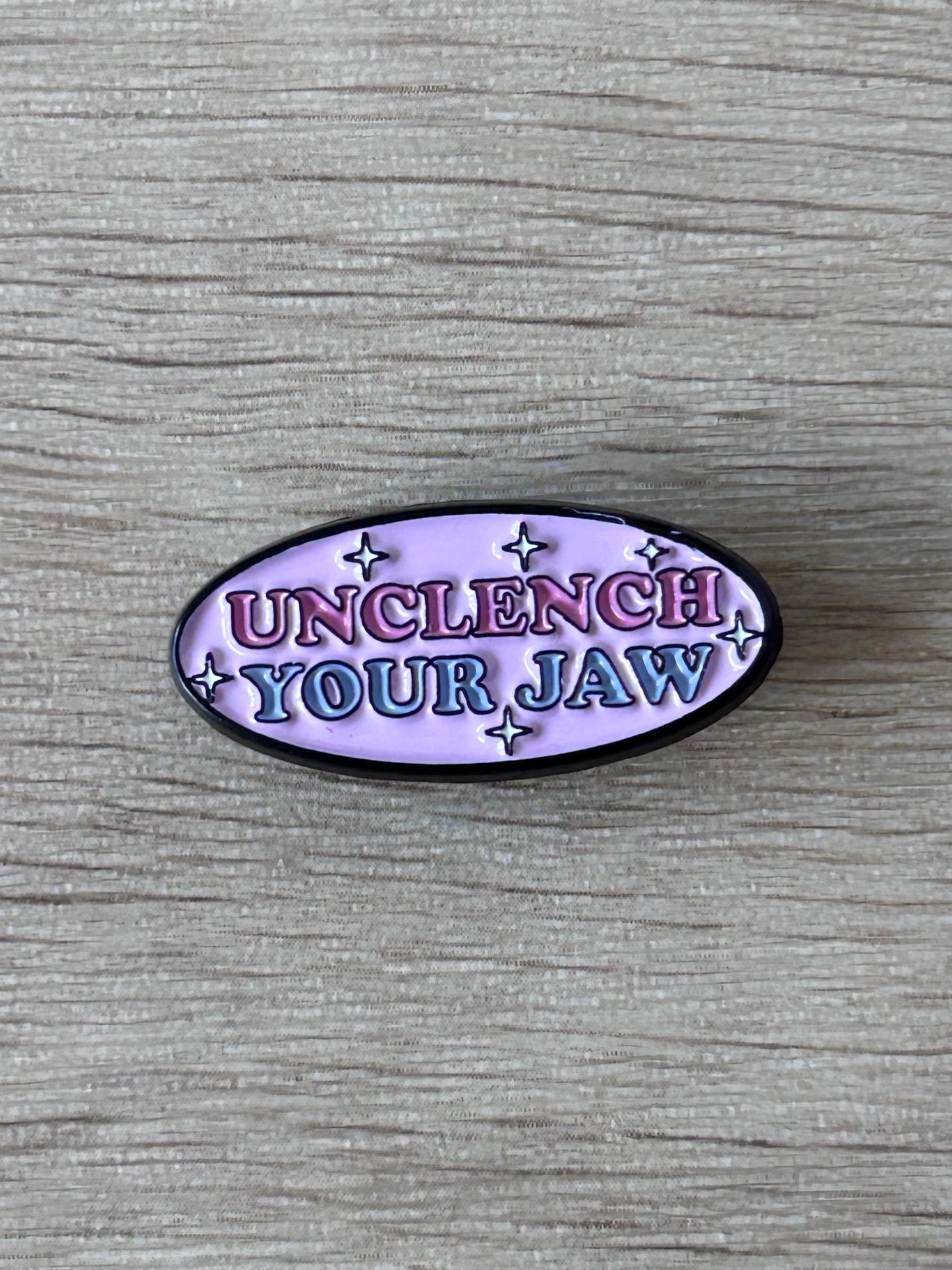 Pin ovale émaillé violet « Unclench Your Jaw » avec étoiles, contour noir