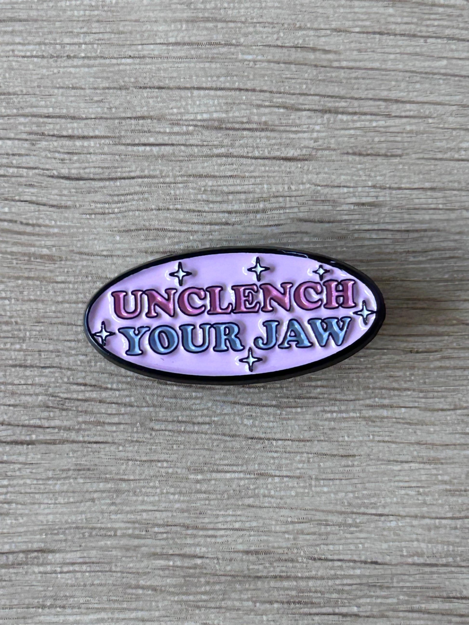 Pin ovale émaillé violet « Unclench Your Jaw » avec étoiles, contour noir