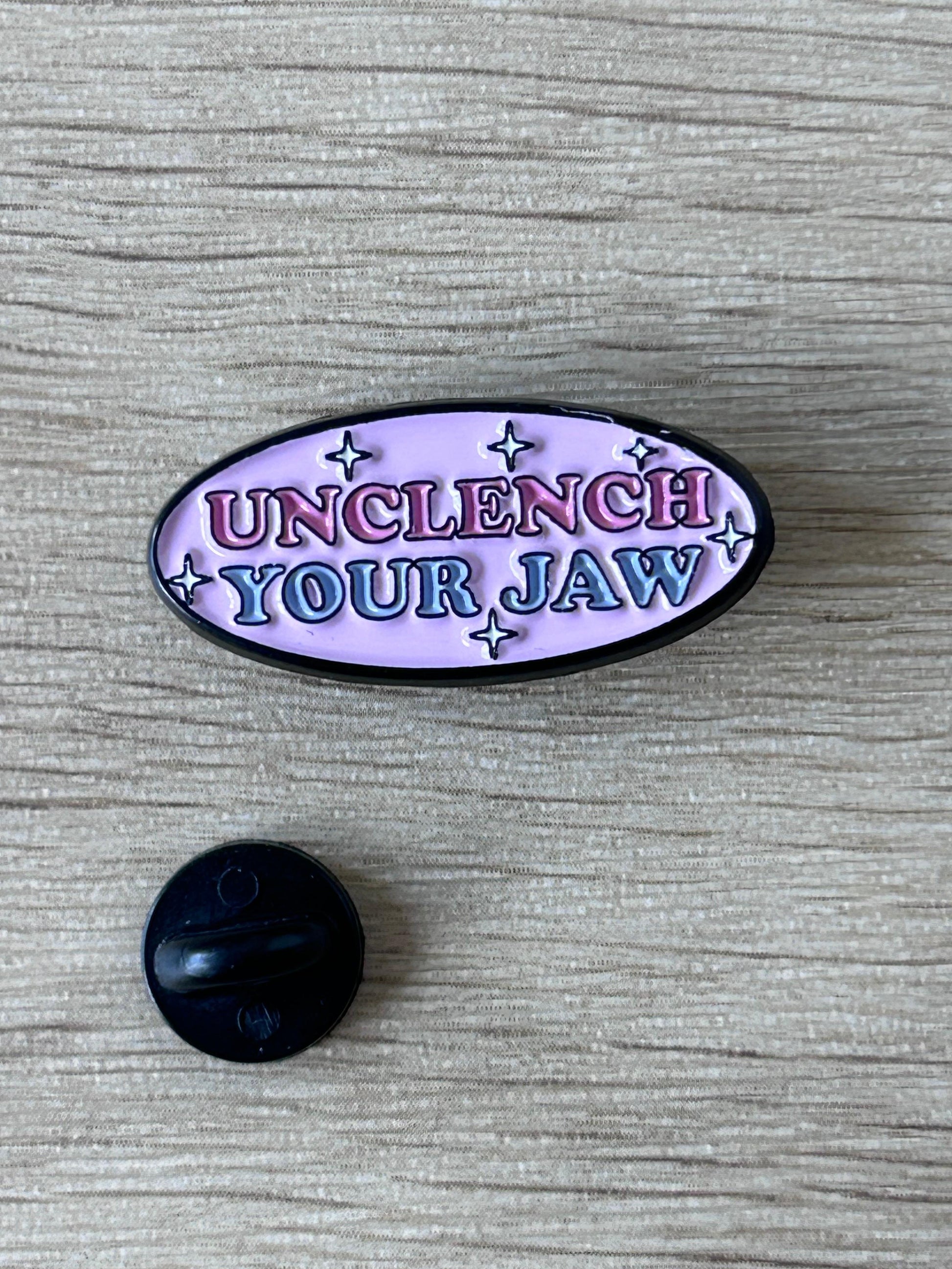 Pin ovale émaillé violet « Unclench Your Jaw » et petit support noir