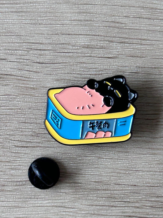 Pin émail chat noir dans boîte bleue bord jaune, vue rapprochée