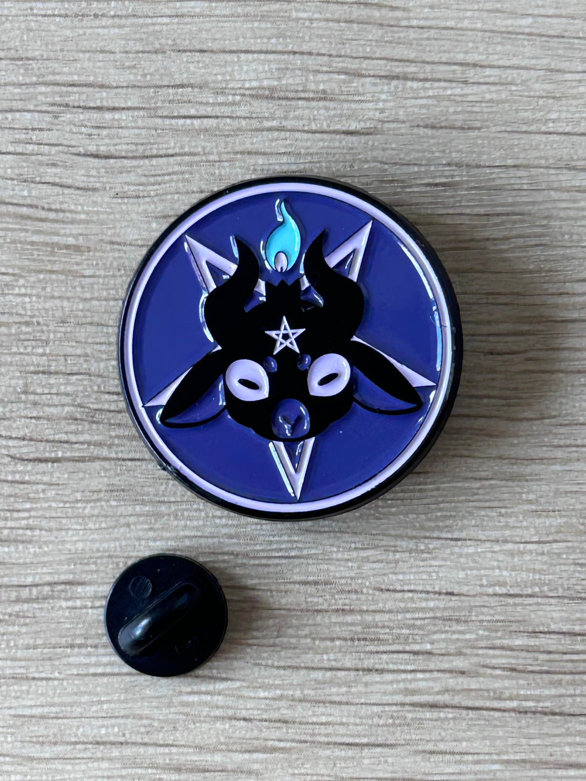 Pin circulaire bleu avec Baphomet noir, étoile et pentagramme, épingle arrière visible
