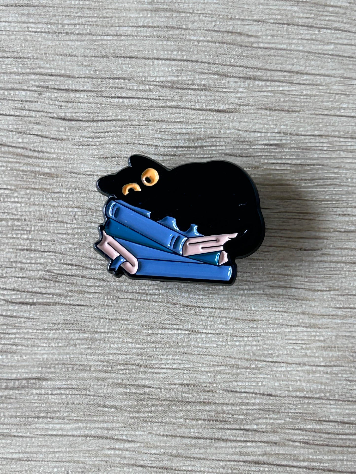 Pin chat noir tenant des livres bleus, petite épingle émaillée.