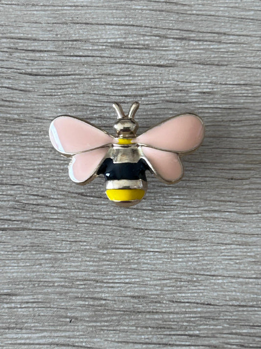 Pin's abeille en relief: ailes roses, corps noir et jaune, antennes dorées.