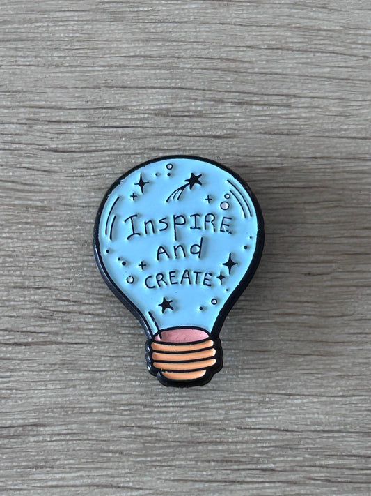 Broche ampoule bleue « Inspire and Create » avec étoiles, contour noir