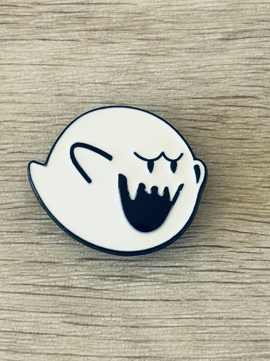 Pin émaillé en forme de fantôme blanc, visage noir souriant, contour bleu.