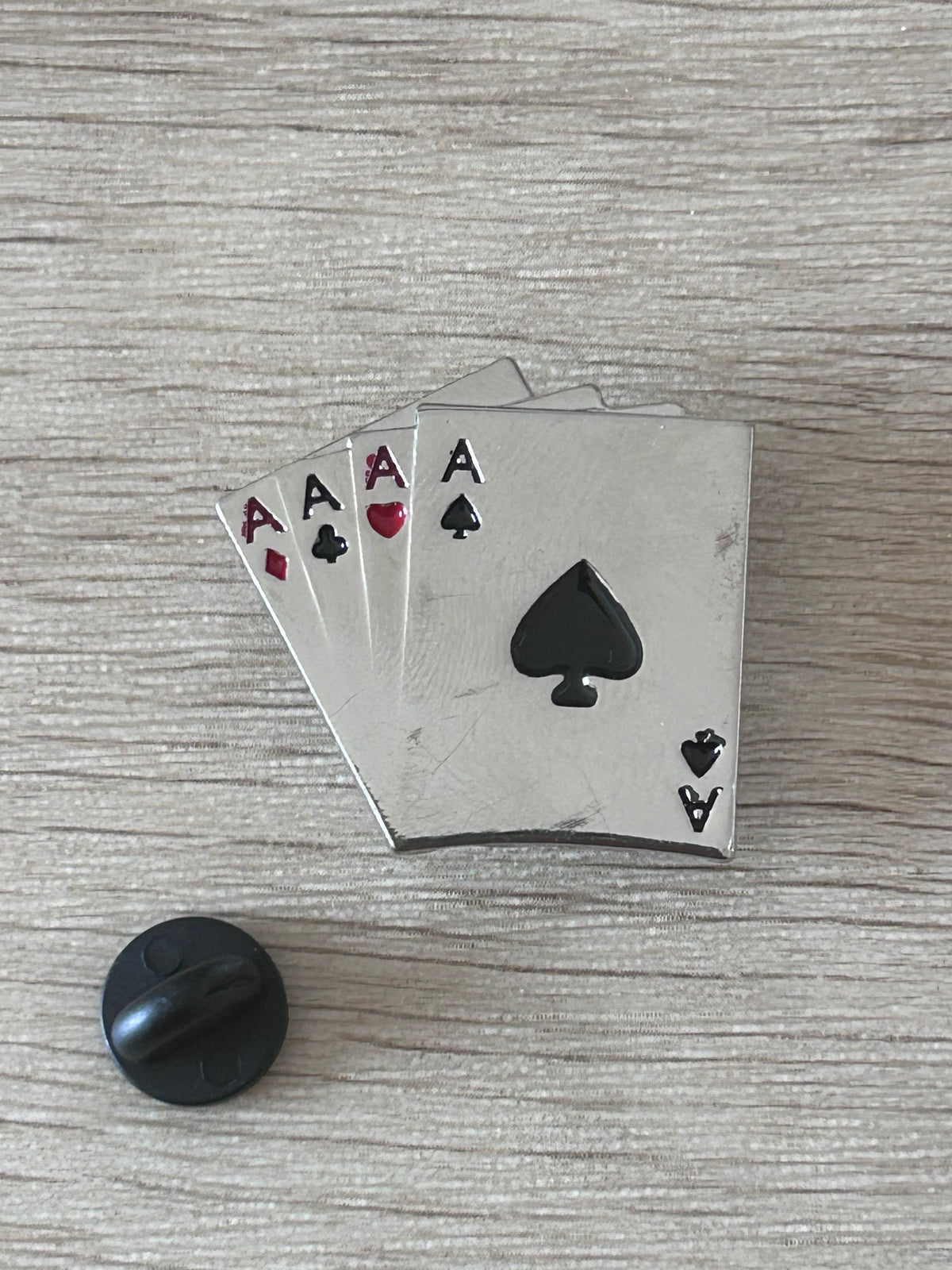 Détail d’un pin's carré d’as avec as de cœur, de pique, de carreau et de trèfle