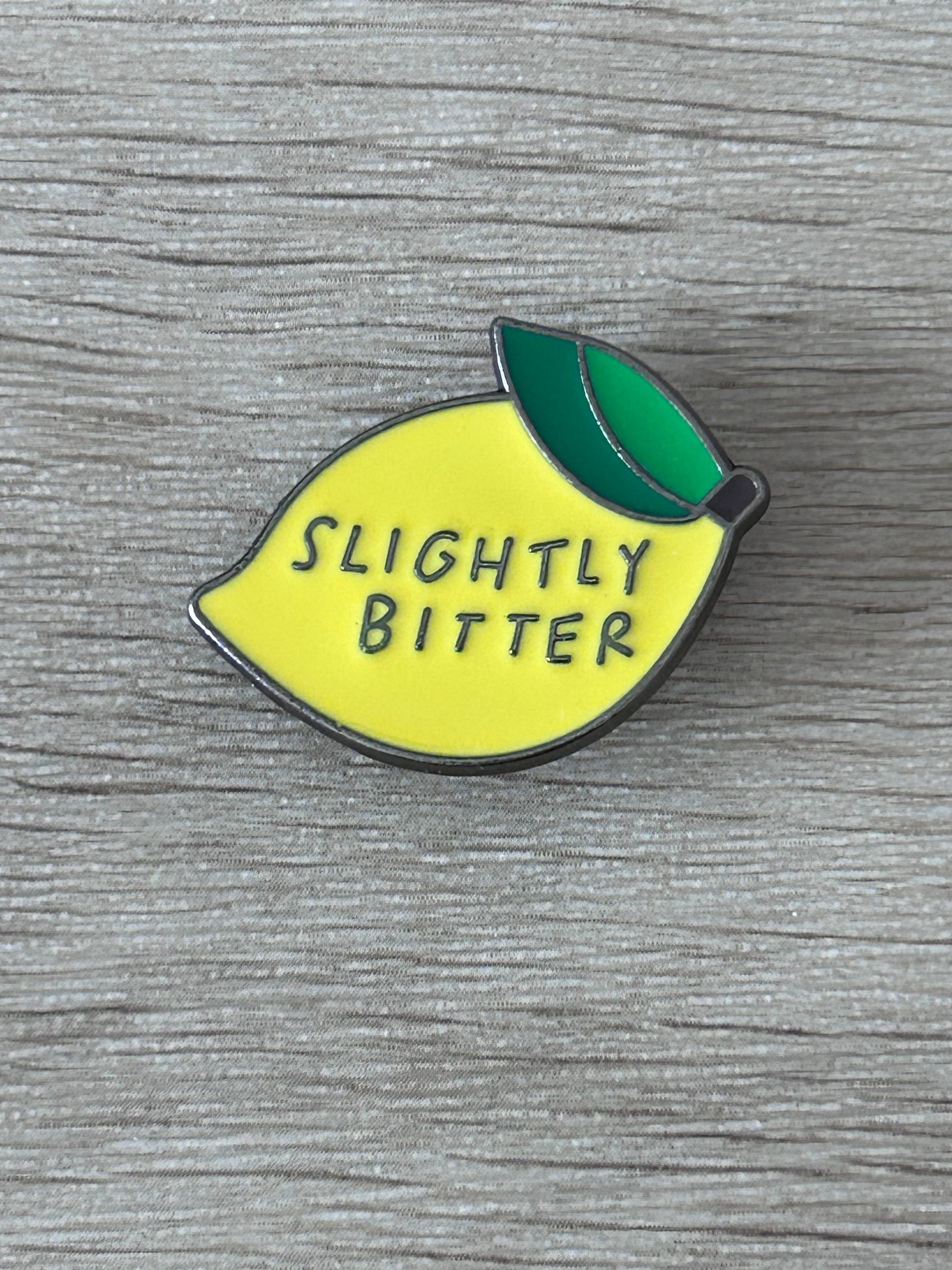 Épingle en forme de citron jaune « Slightly Bitter » avec feuille verte.