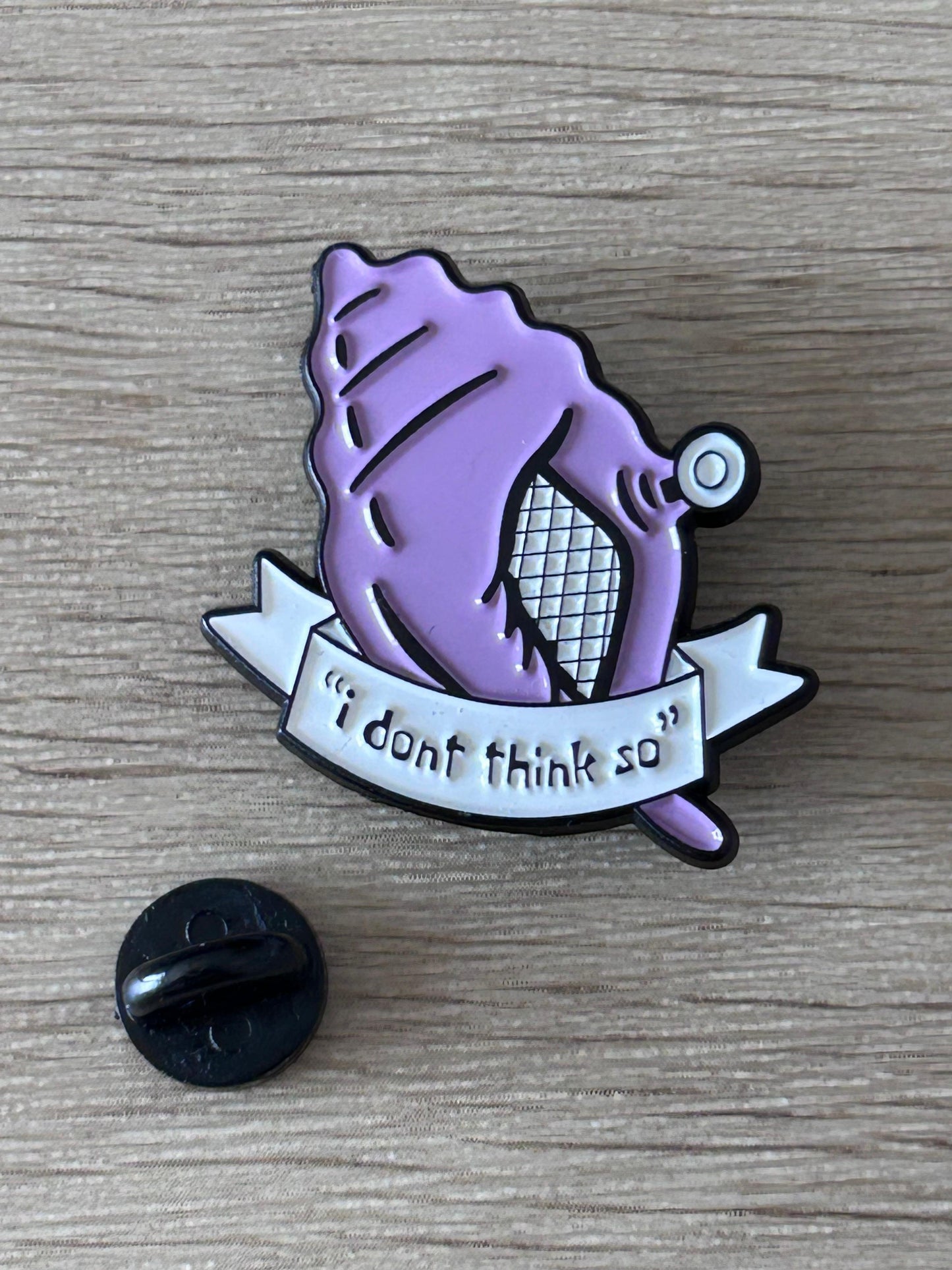 Pin en émail violet, dos noir visible, ruban «I dont think so».