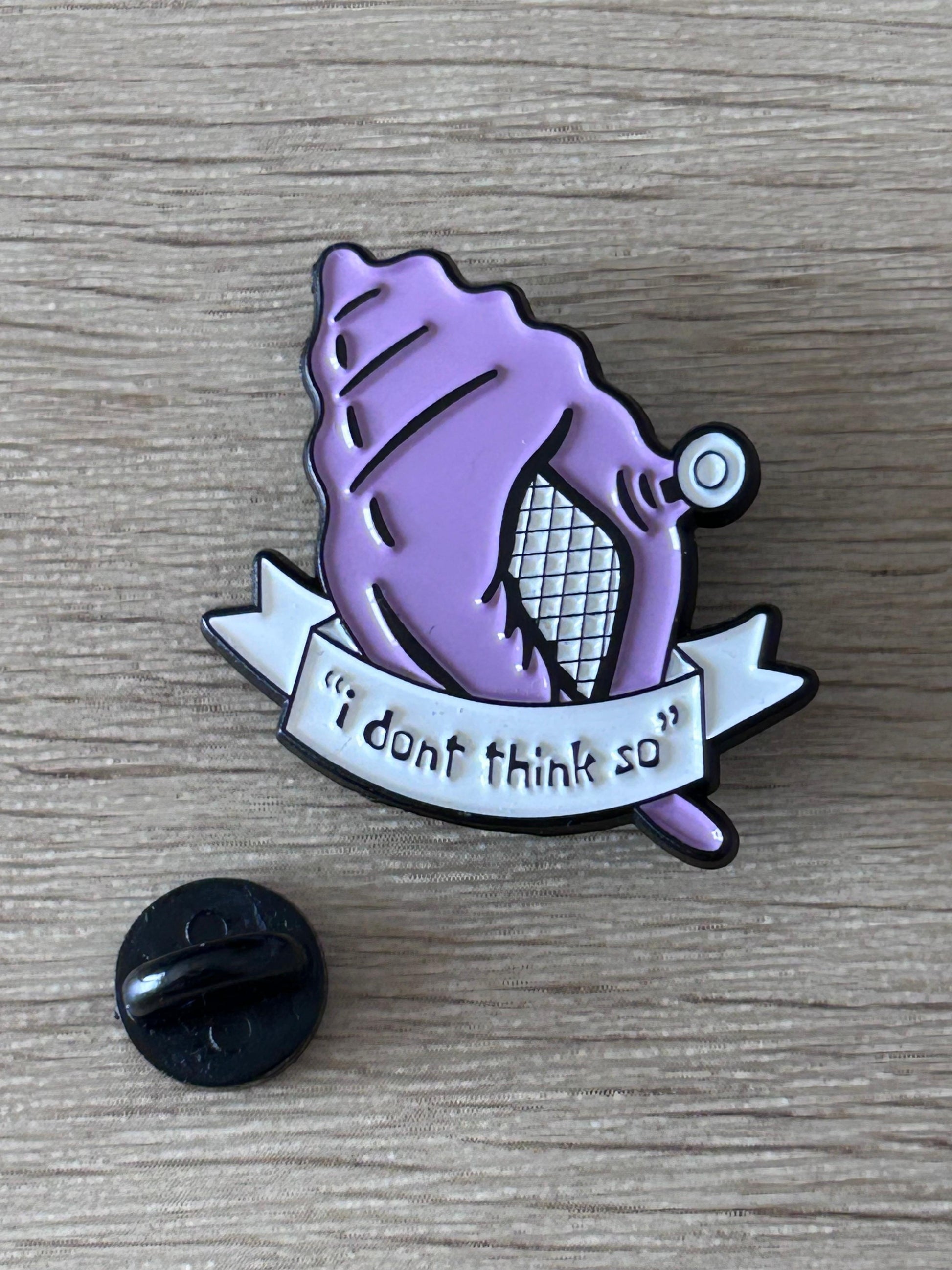 Pin en émail violet, dos noir visible, ruban «I dont think so».