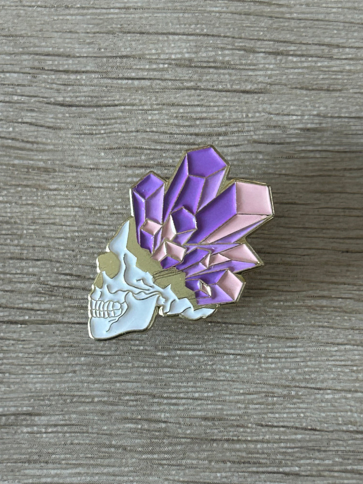 Vue rapprochée du pin's crâne et cristaux violets