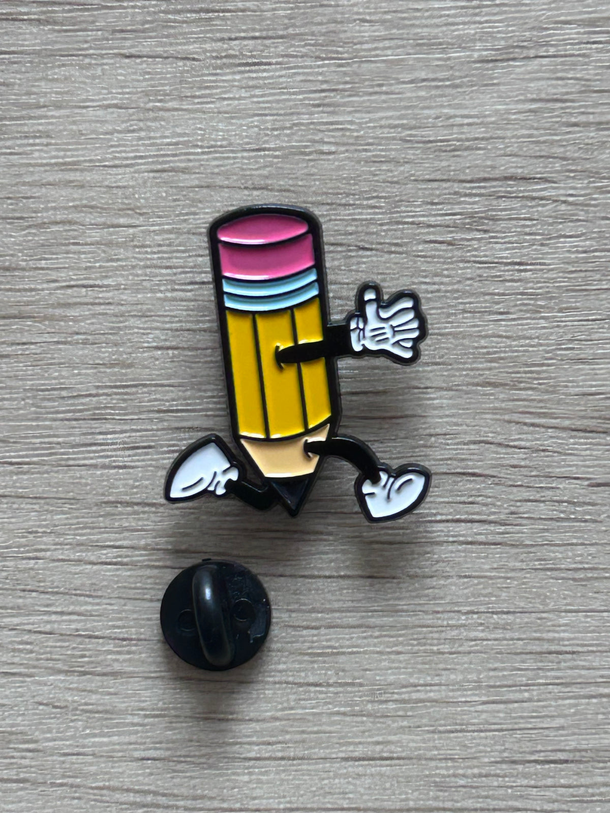 Détail du pin's crayon jaune avec ses bandes colorées