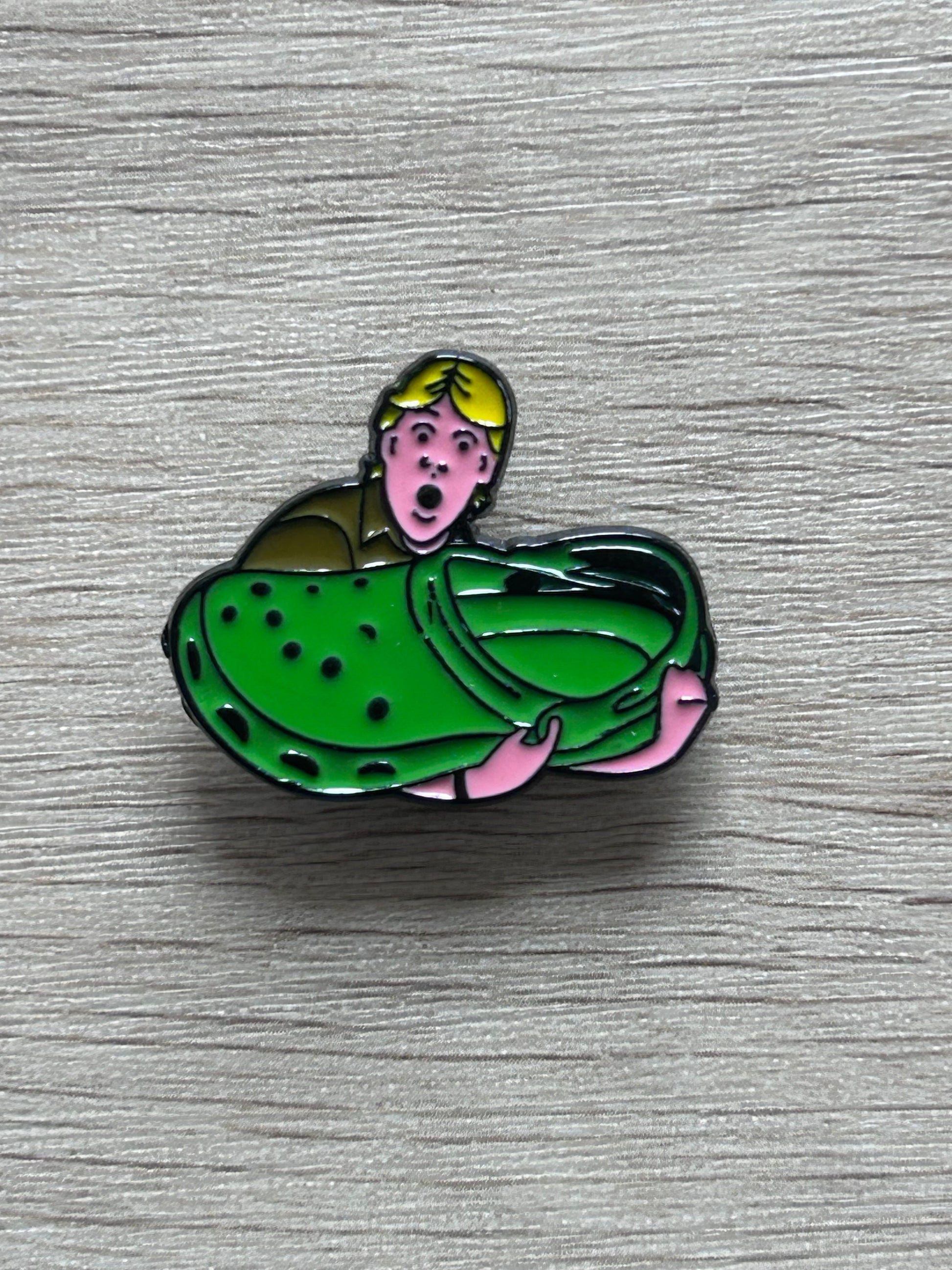 Pin's sabot vert avec personnage rose, jaune et noir