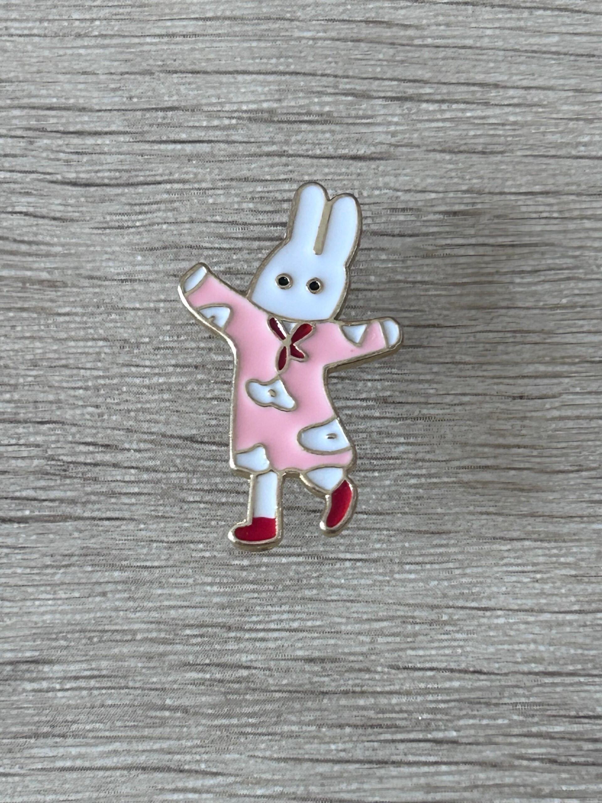 Pin's de lapin danseur en robe rose, bras levés et chaussures rouges