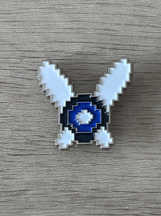 Broche fée pixel art bleu marine et bleu clair, ailes en V, contour argenté.