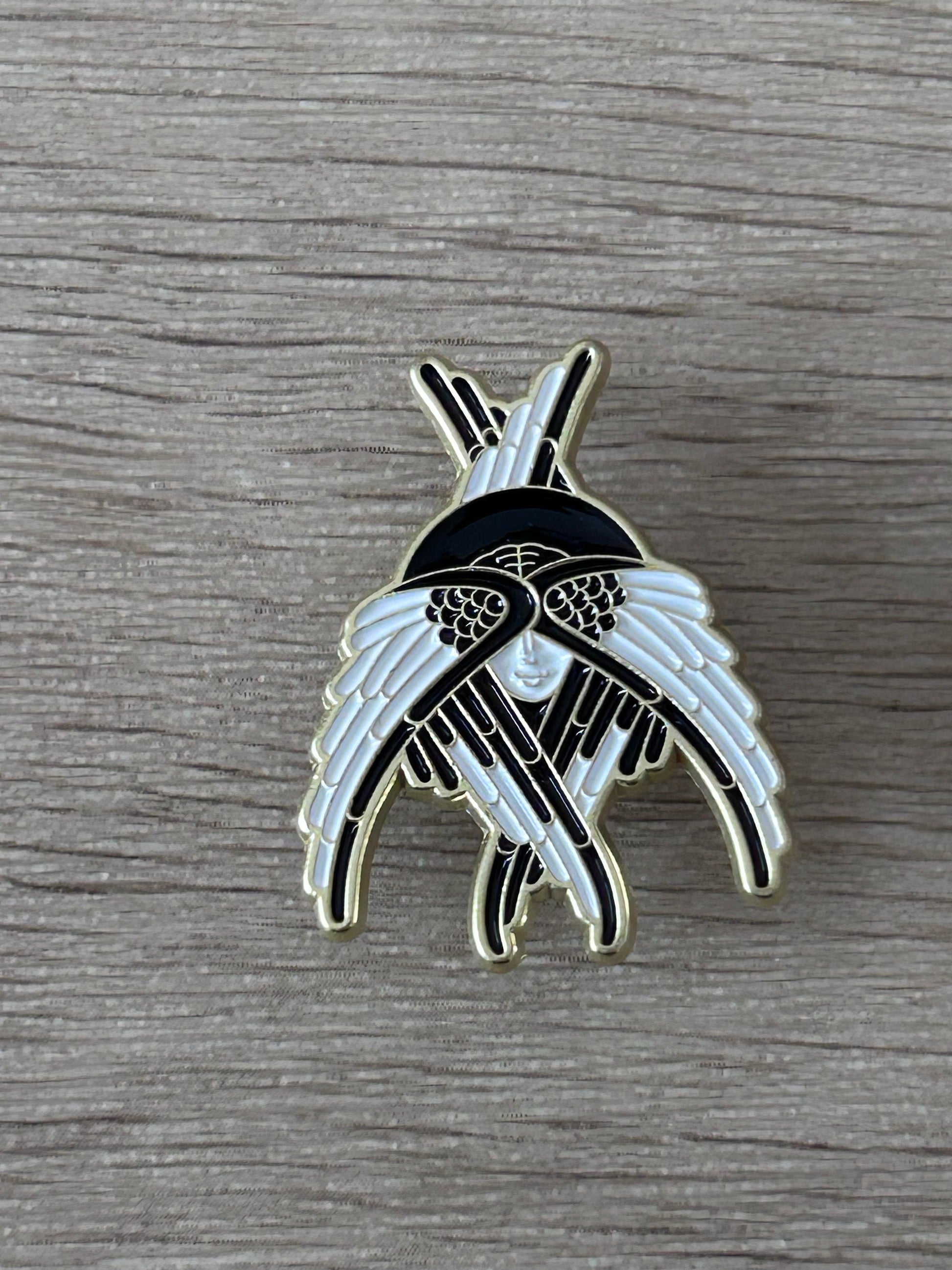 Pin en forme d’ailes d’oiseaux, noir et bleu clair, détail central argenté