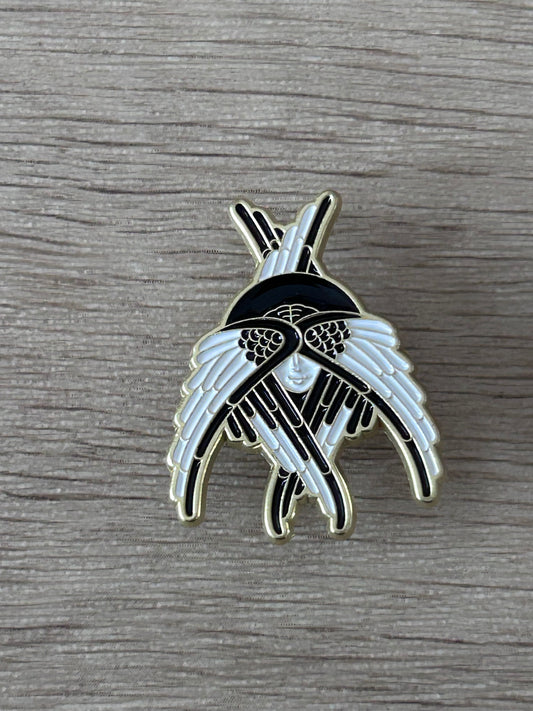 Pin en forme d’ailes d’oiseaux, noir et bleu clair, détail central argenté