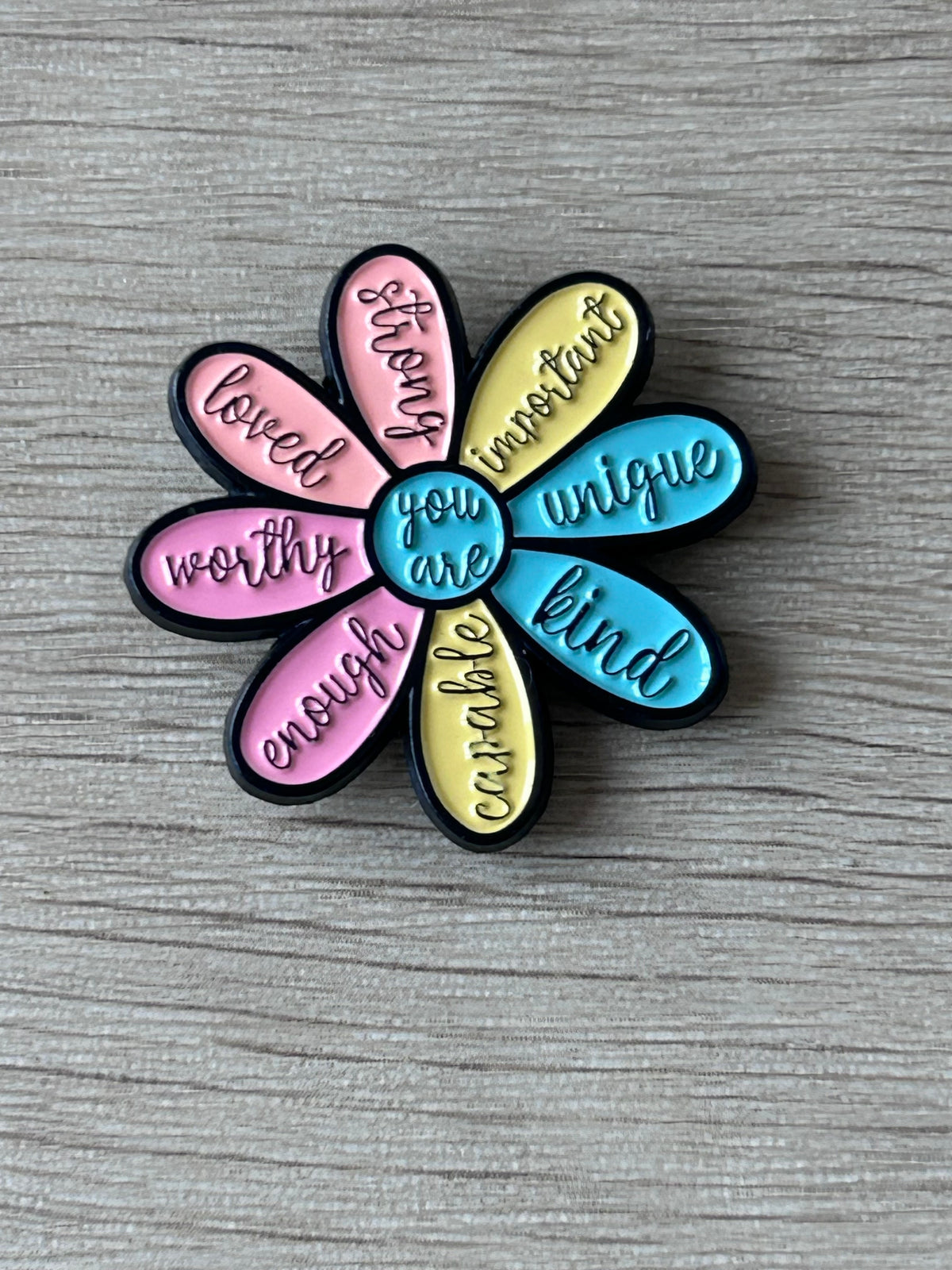 Épinglette en forme de fleur à 7 pétales émaillés, inscriptions décoratives multicolores