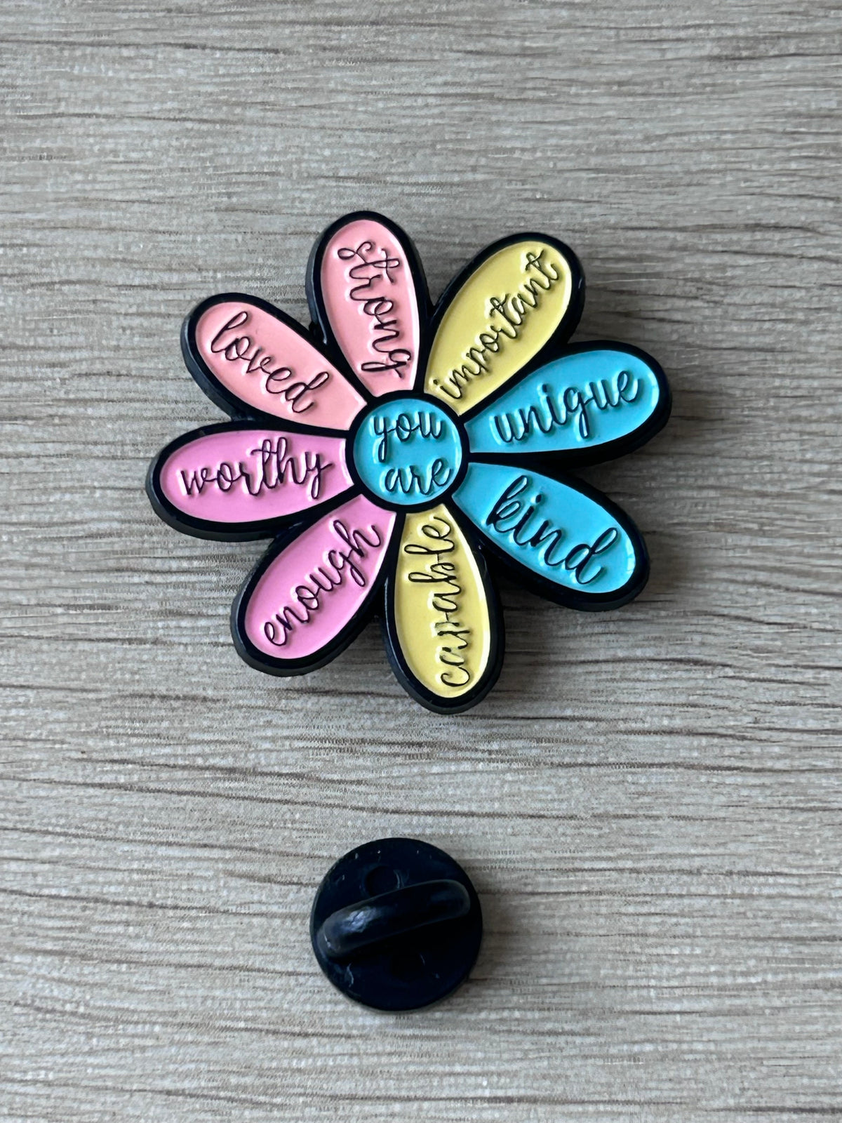 Épinglette en forme de fleur multicolore avec attache arrière visible