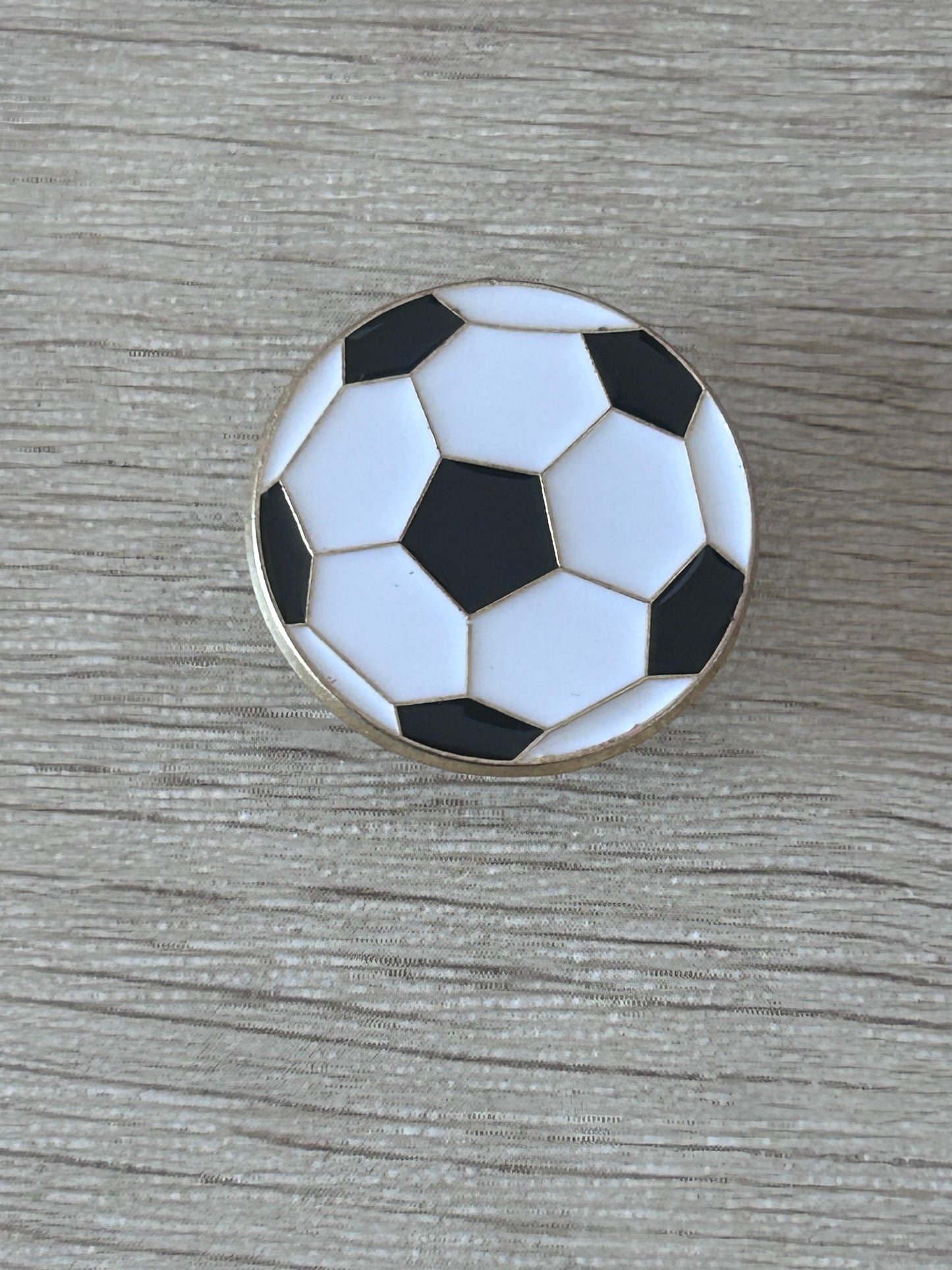 Pin's ballon de football vue de face, émail noir et blanc contour doré