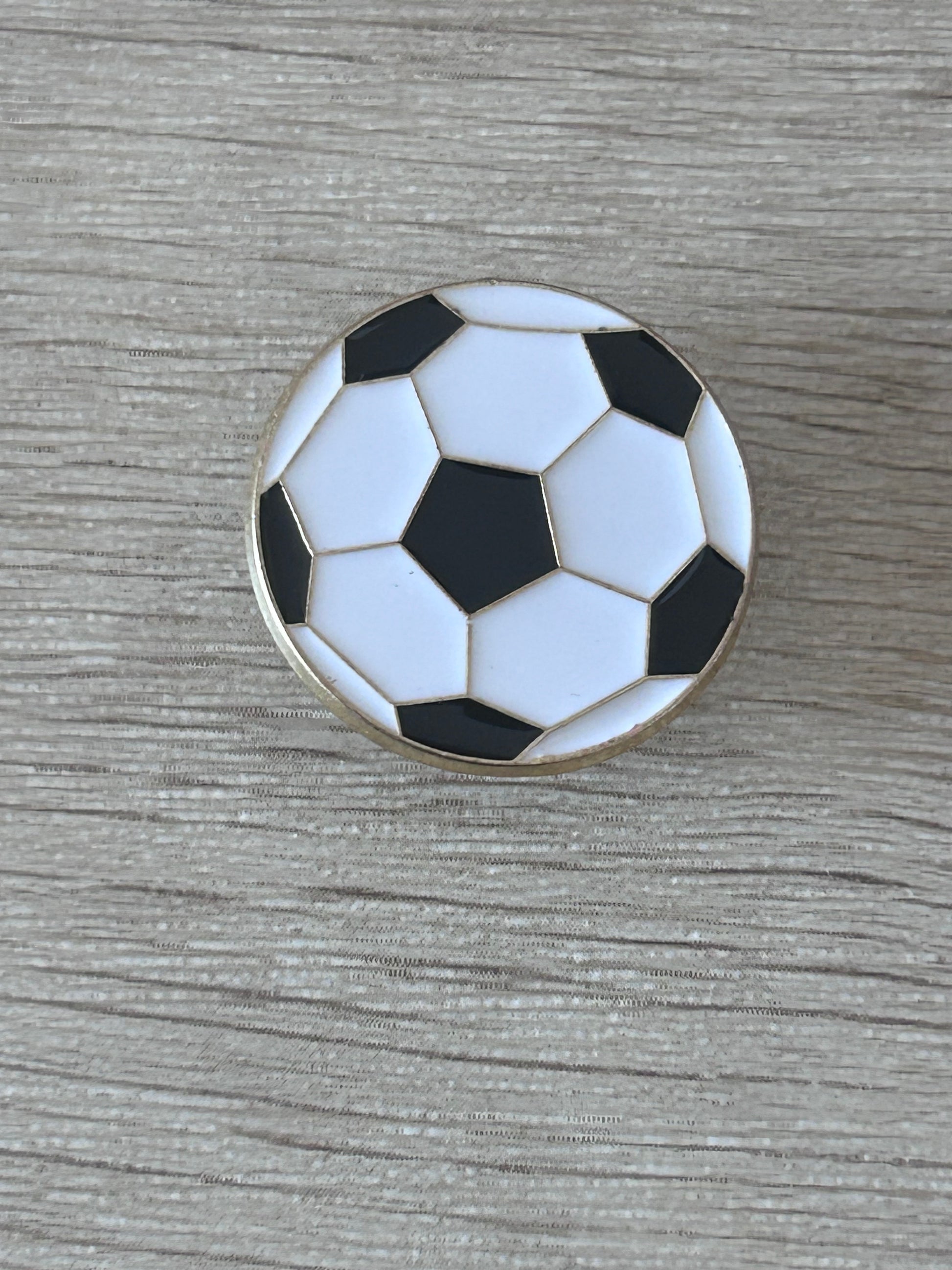 Pin's ballon de football vue de face, émail noir et blanc contour doré
