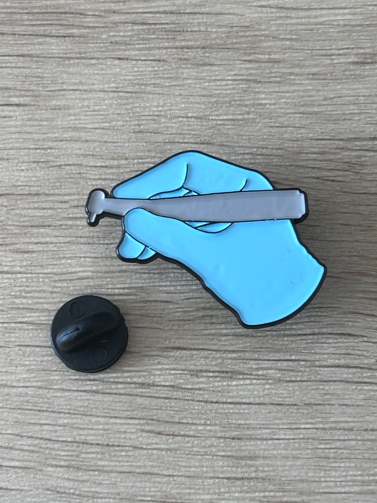 Pin's machine à coudre bleue sur fond en bois