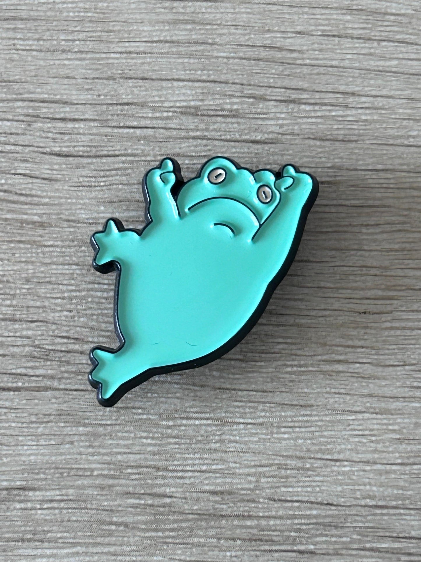 Épingle grenouille turquoise en pose gym, vue de face
