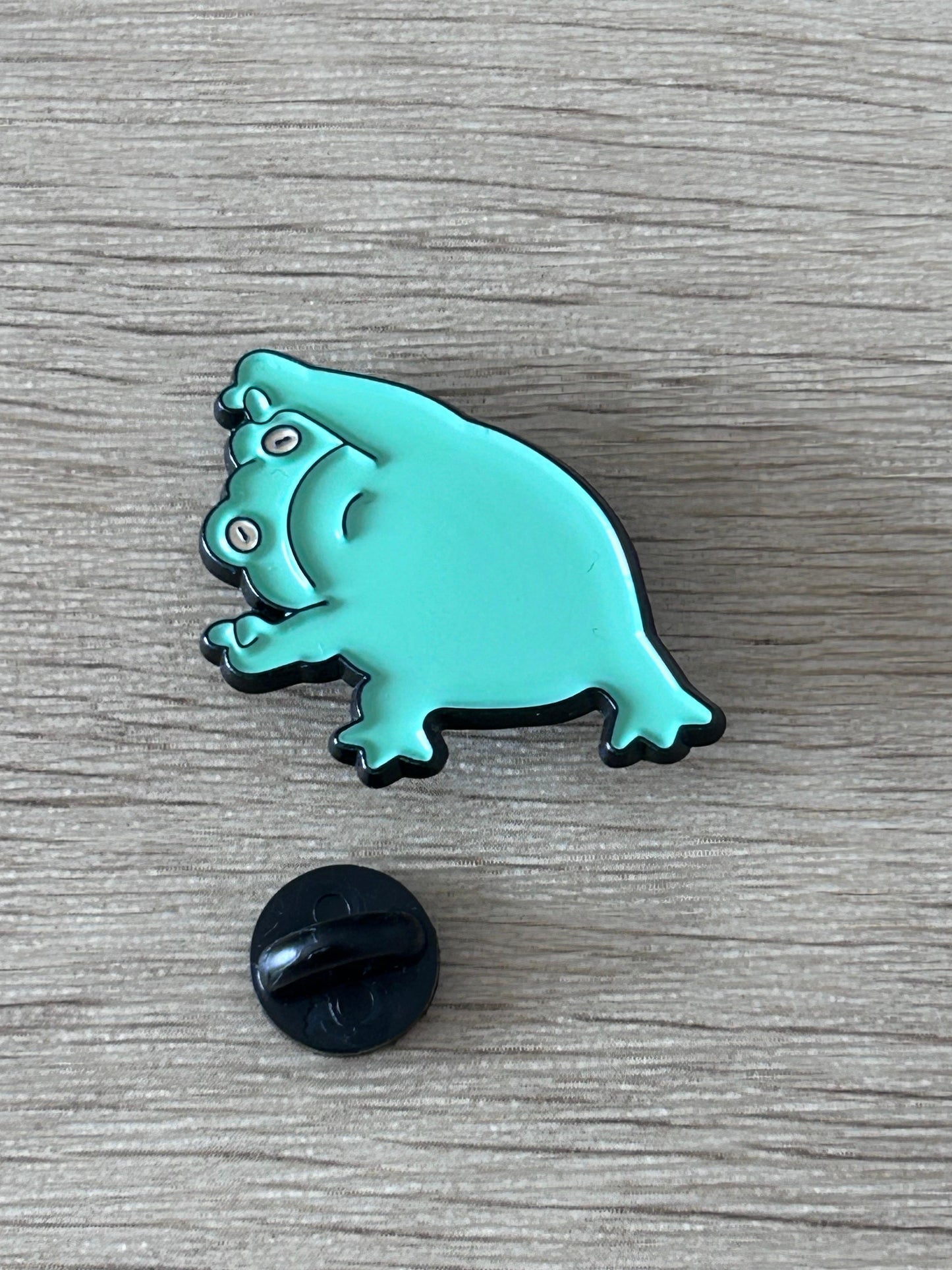 Épingle grenouille turquoise avec fixation noire, vue rapprochée