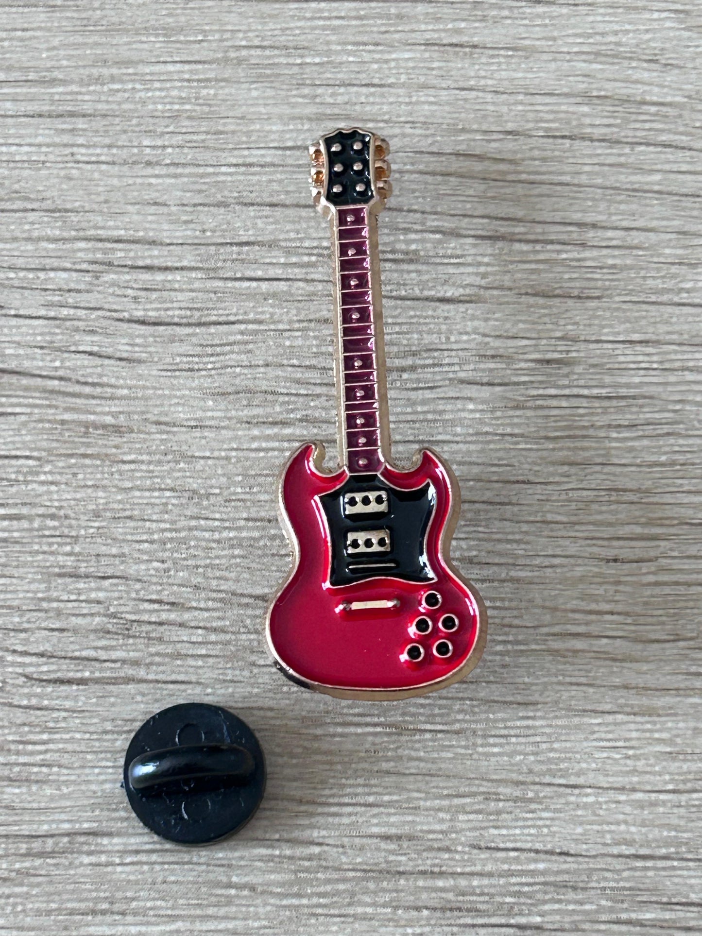 Guitare électrique rouge en émail avec épingle et support noir