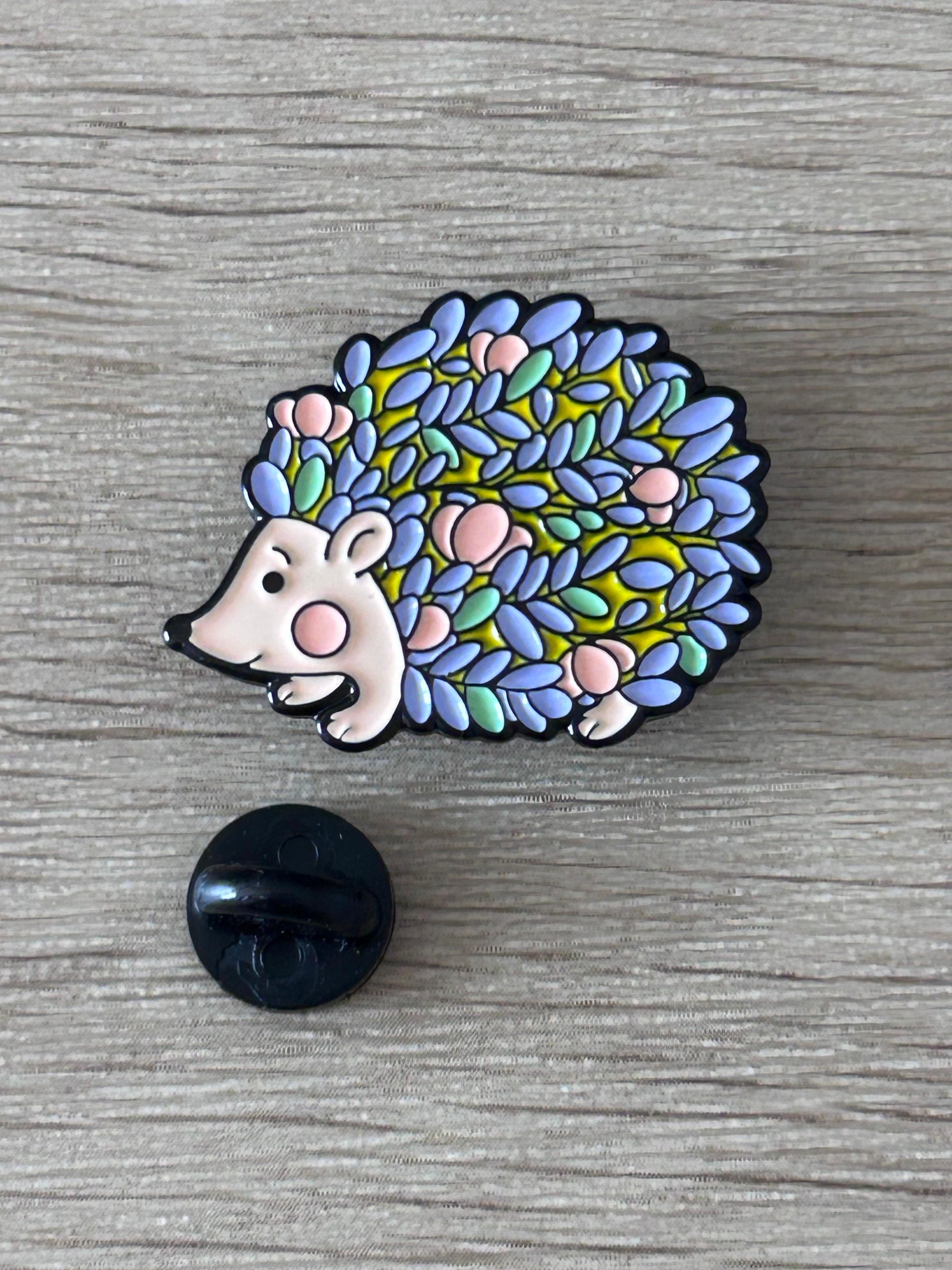 Pin's hérisson multicolore émaillé, tête blanche et piquants colorés, attache noire en plastique