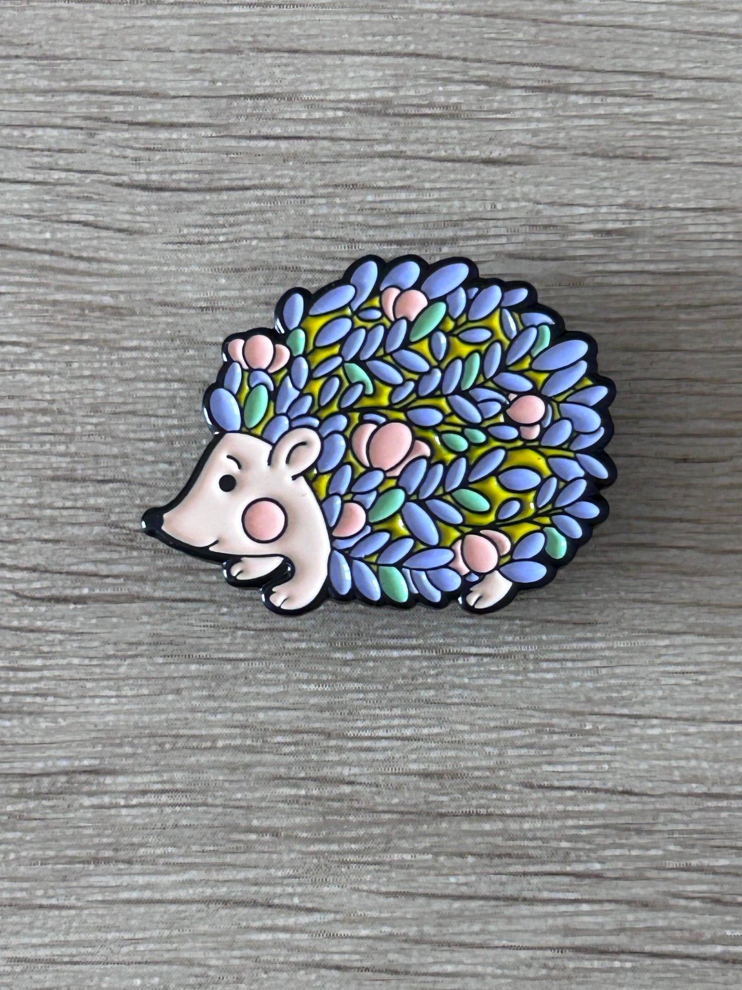 Pin's hérisson multicolore émaillé, tête blanche et piquants aux tons bleu, vert et rose