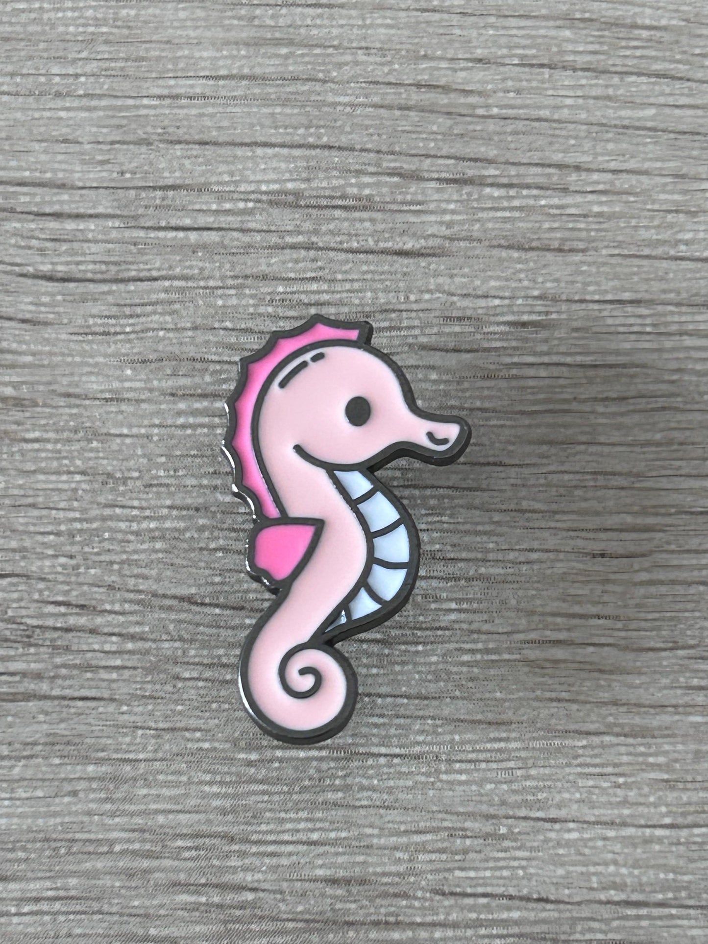 Pin hippocampe rose, motif debout avec queue en spirale.