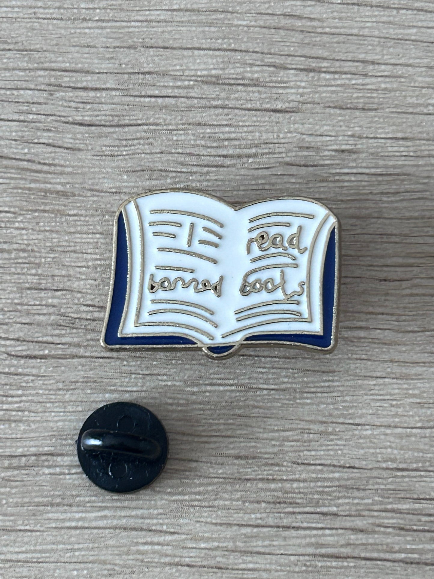 Pin livre ouvert émaillé bleu et blanc, avec dos d’attache noir