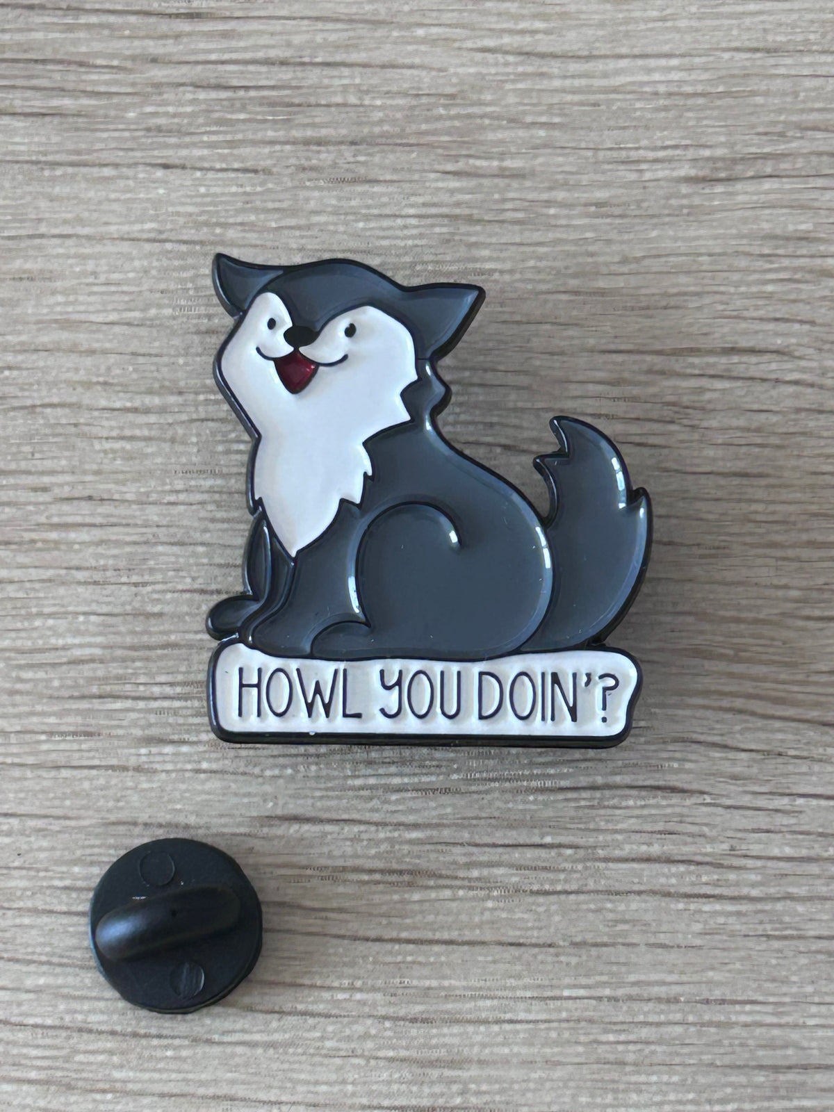 Détail du pin's loup noir et blanc avec message humoristique