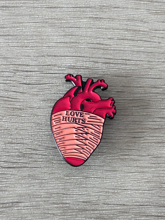 Pin cœur anatomique rouge avec texte « Love Hurts »