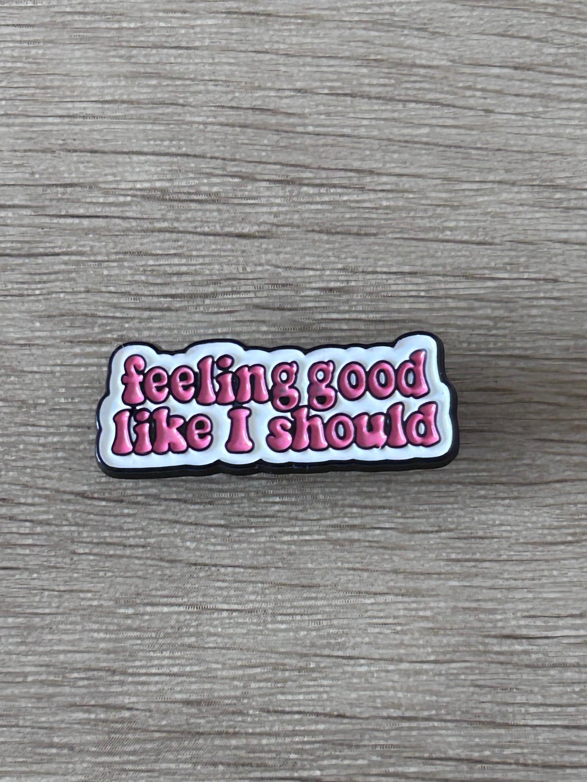 Broche émaillée noire avec texte « feeling good like I should »