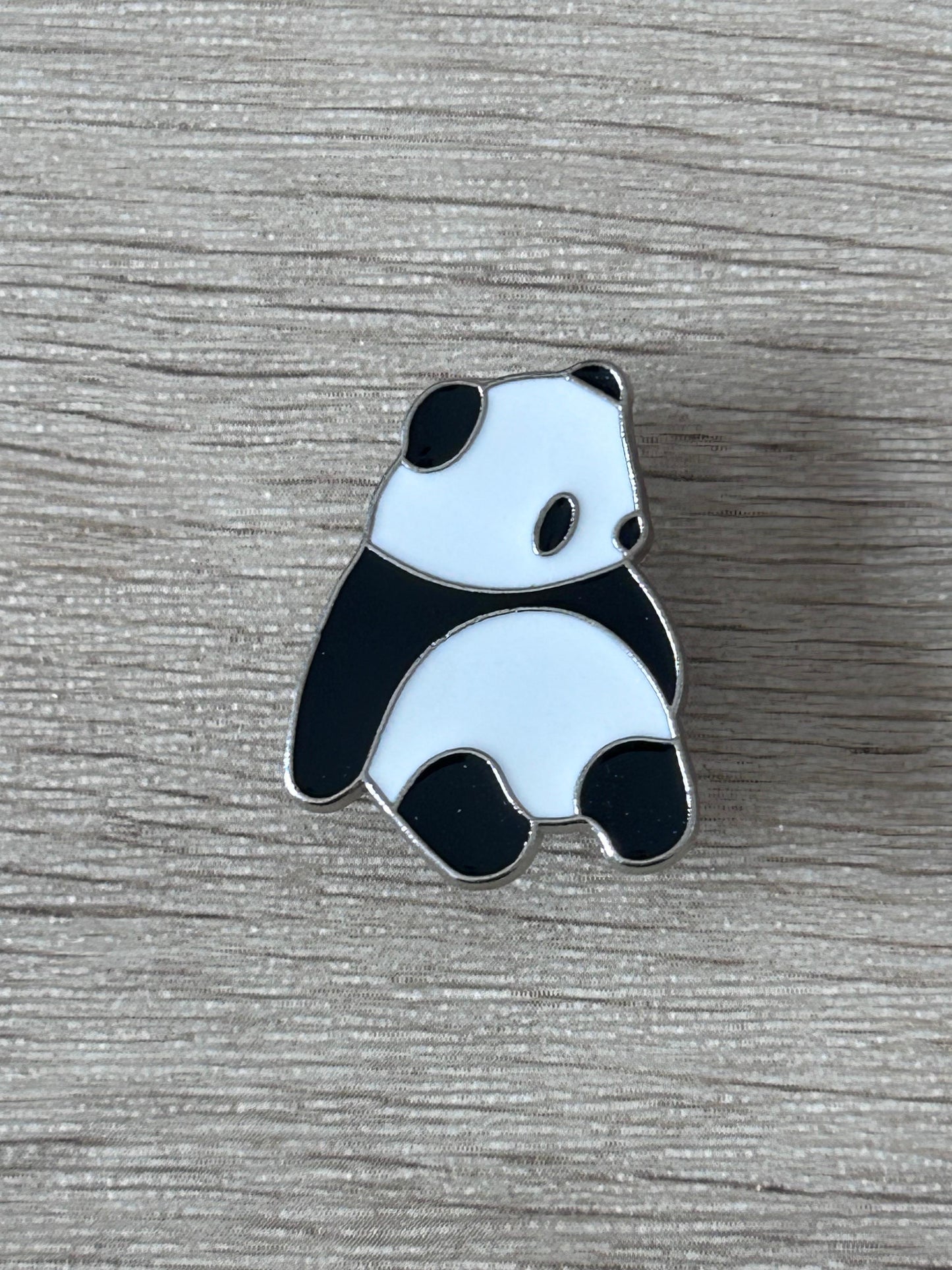 Pin's panda assis émaillé noir et blanc, face avant visible.