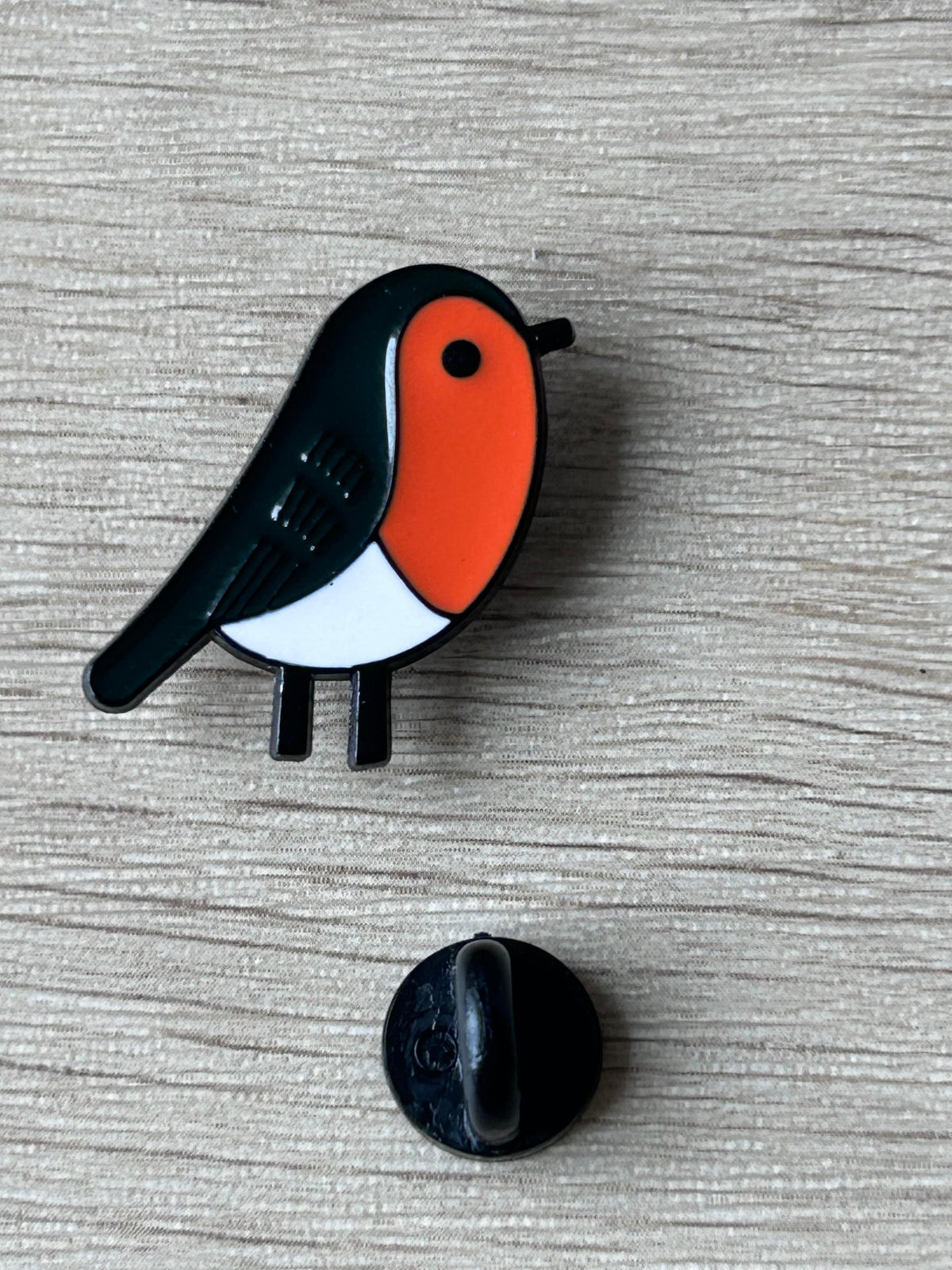 Broche oiseau émail rouge-gorge : face orange et noire, avec attache noire arrière
