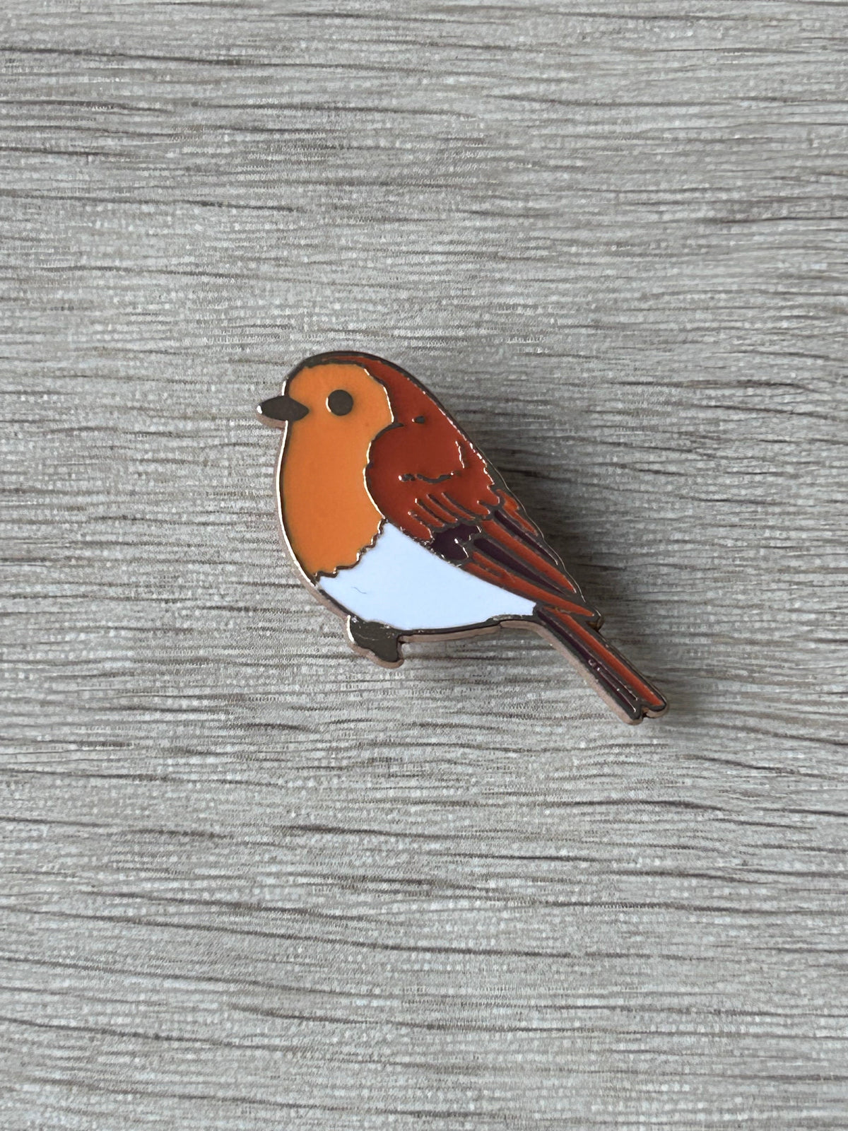 Broche rouge-gorge en émail orange, blanc et brun, vue rapprochée